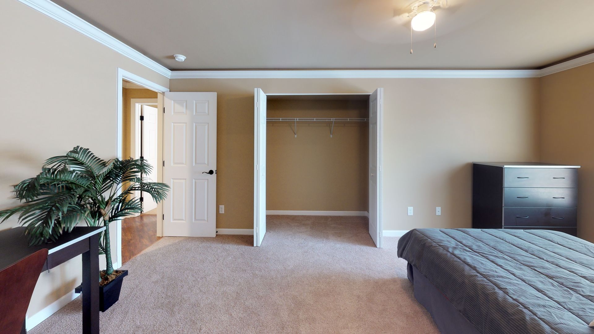 A bedroom with a bed , dresser , and closet.