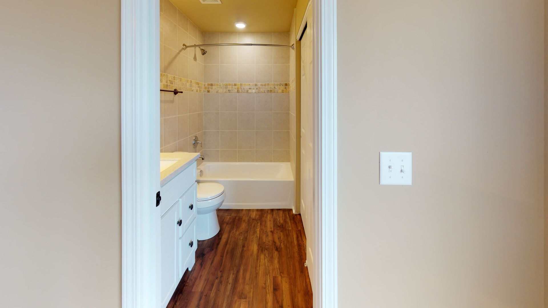 A bathroom with a toilet , sink , and bathtub.