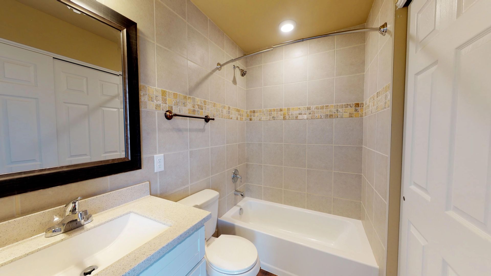 A bathroom with a toilet , sink , tub and mirror.