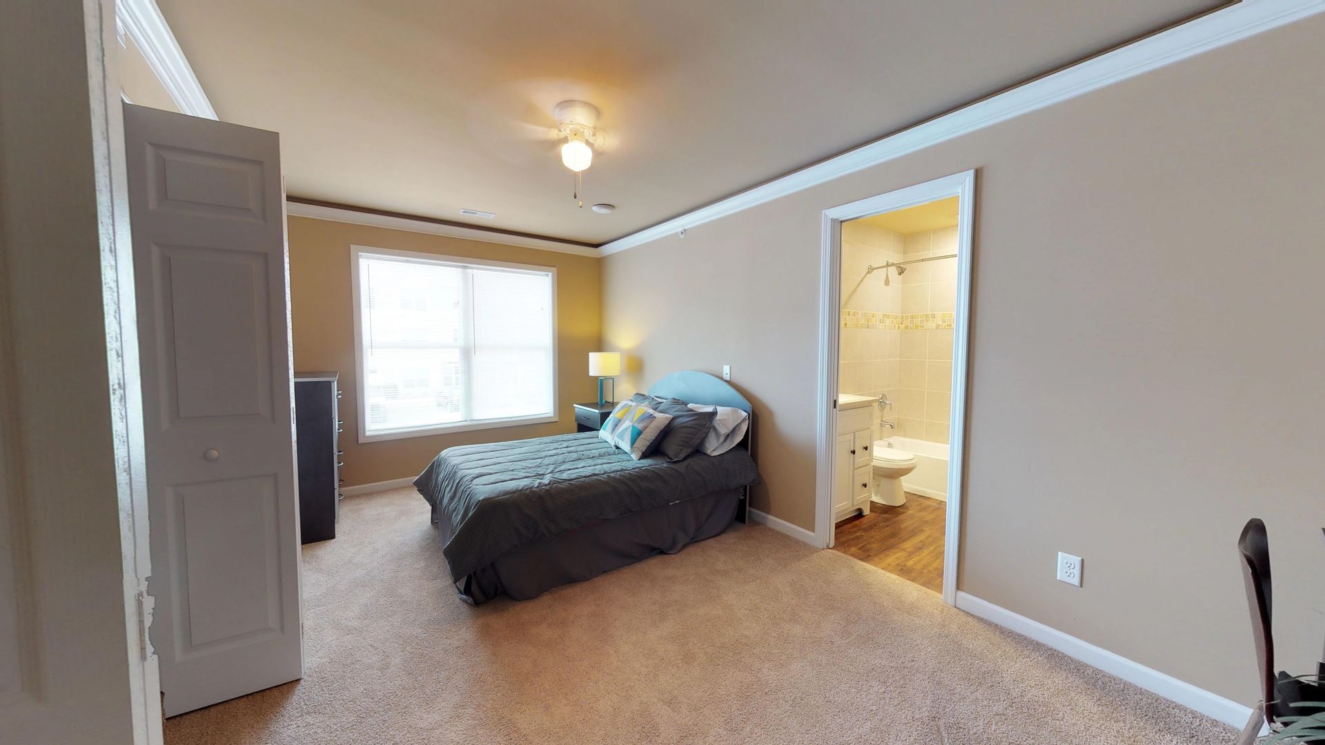 A bedroom with a large bed and a bathroom.