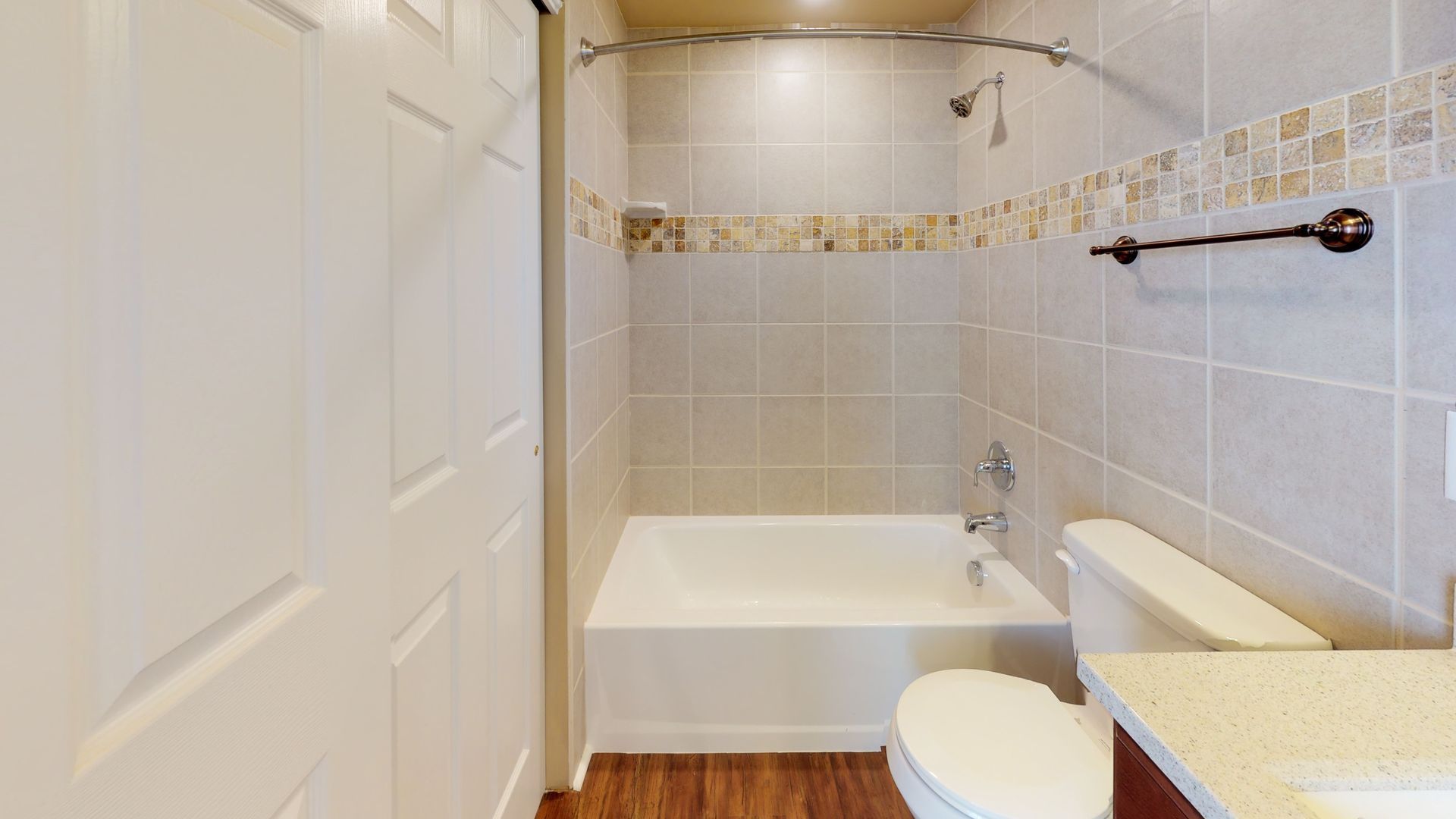 A bathroom with a toilet , sink , bathtub and shower.