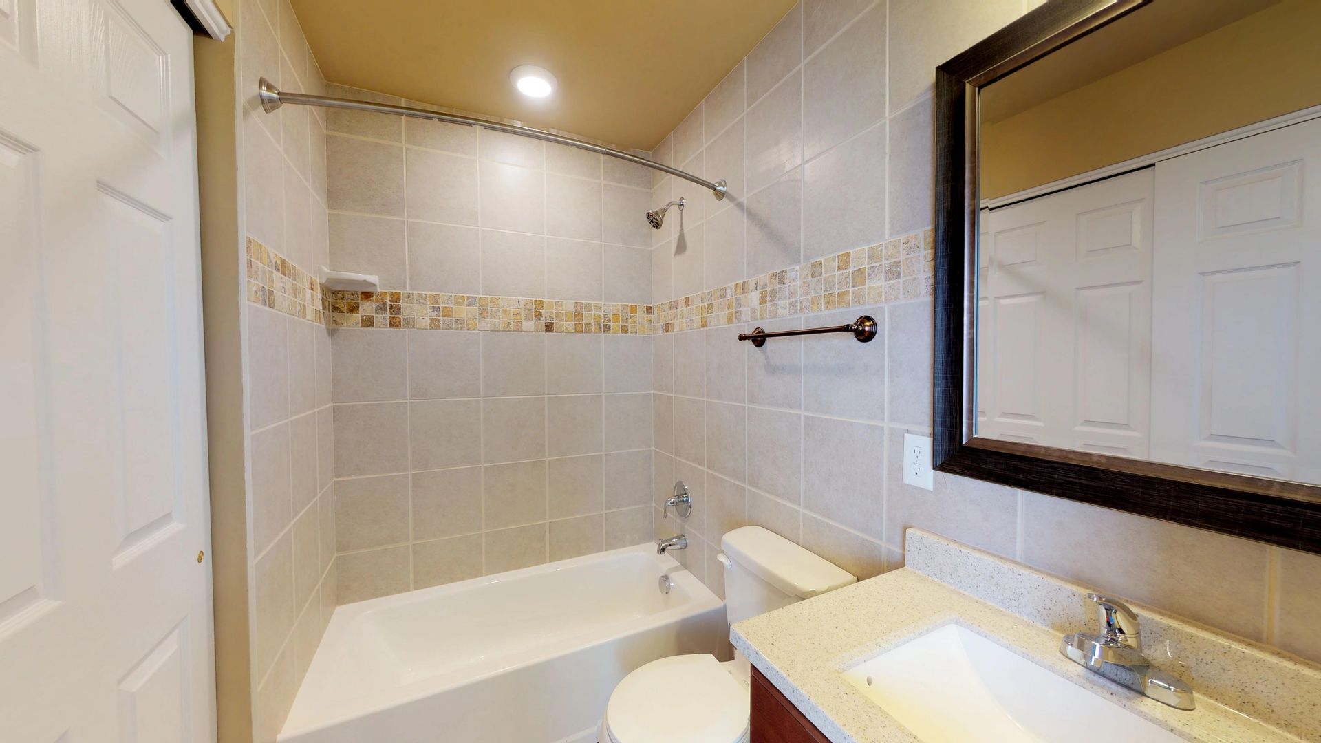 A bathroom with a tub , toilet , sink and mirror.