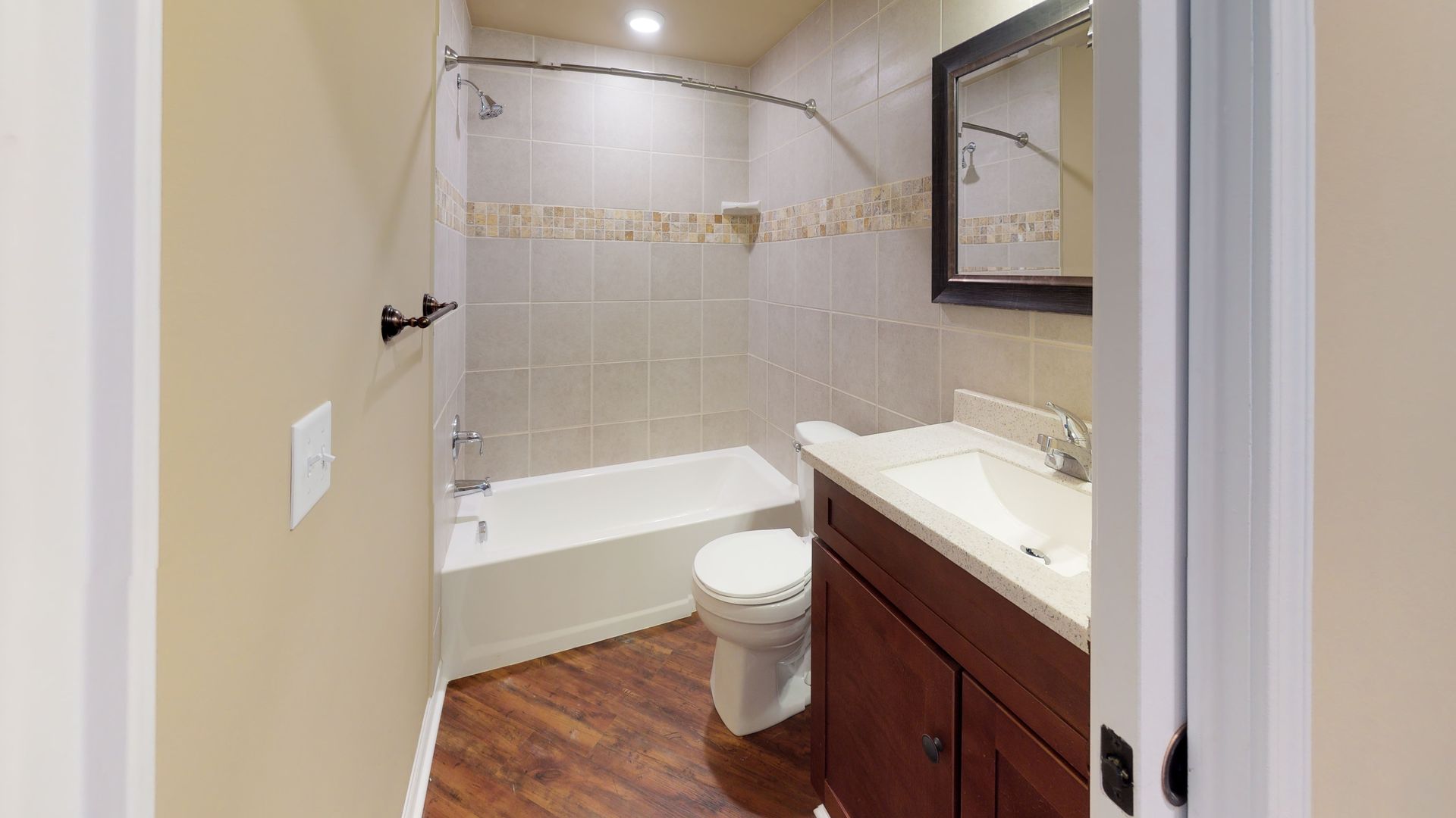 A bathroom with a toilet , sink , bathtub and mirror.