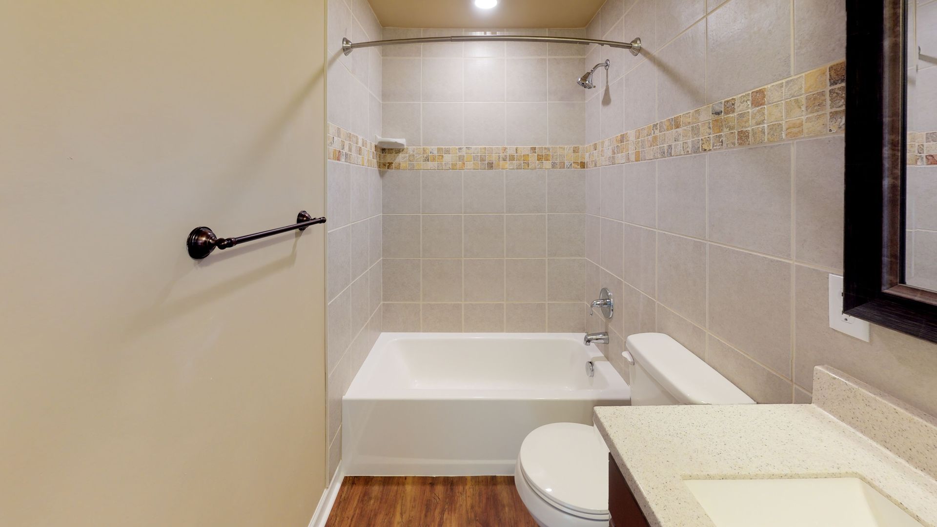 A bathroom with a tub , toilet , sink and mirror.