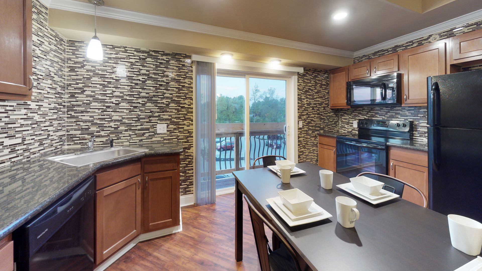 A kitchen with a dining table and a sliding glass door.