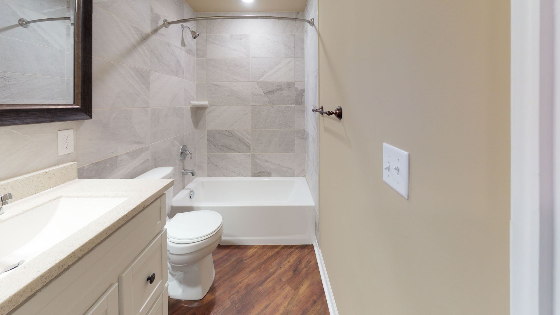 A bathroom with a toilet , sink , bathtub and shower.