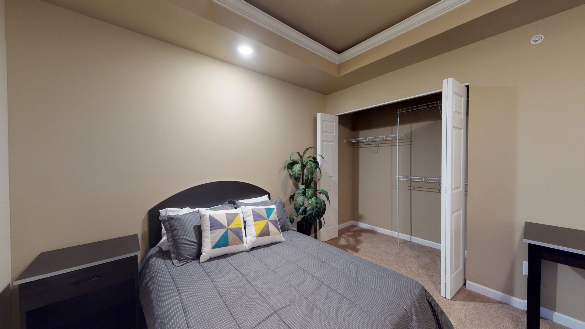 A bedroom with a bed , nightstand , and closet.