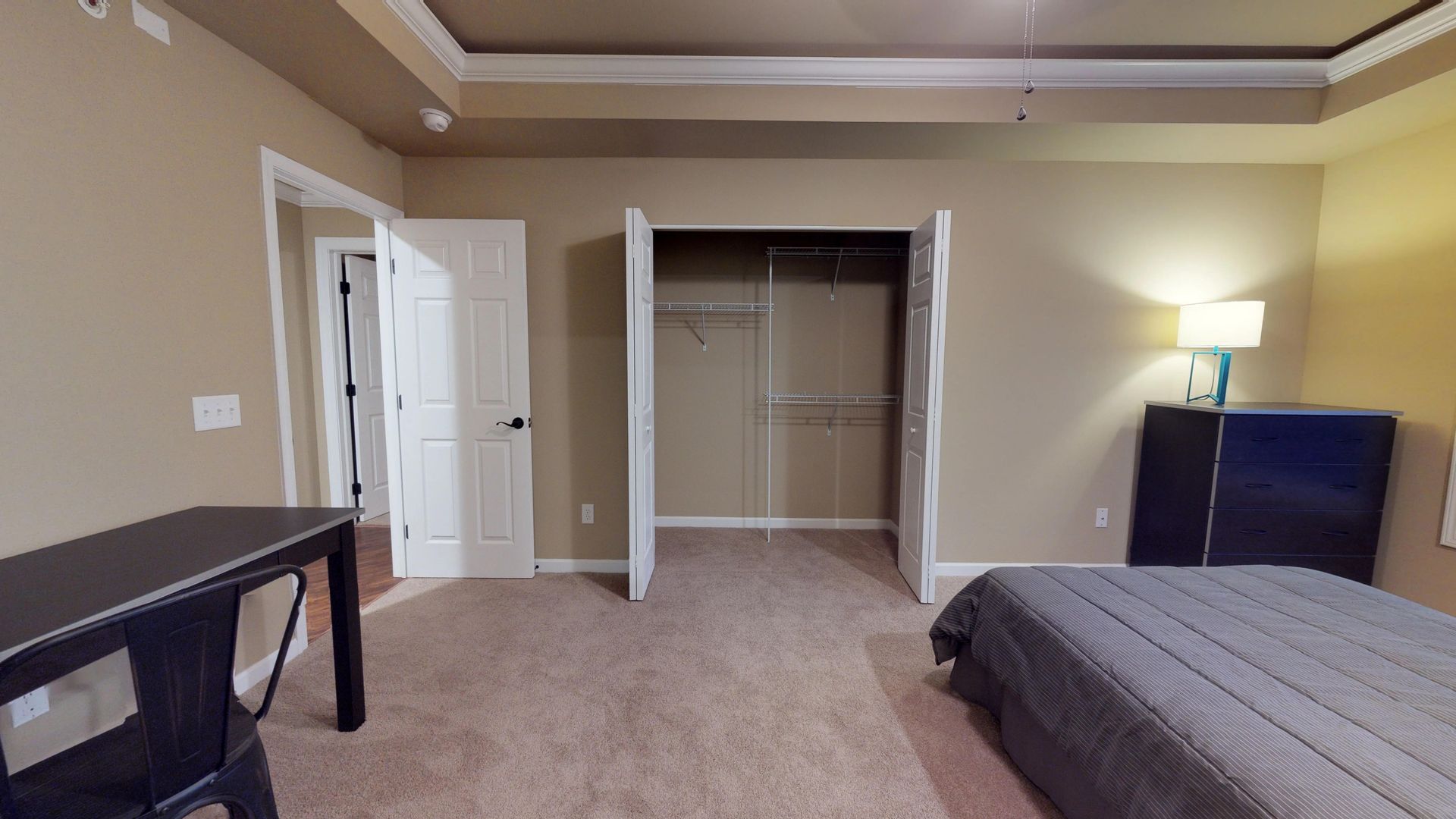 A bedroom with a bed , desk , and closet.