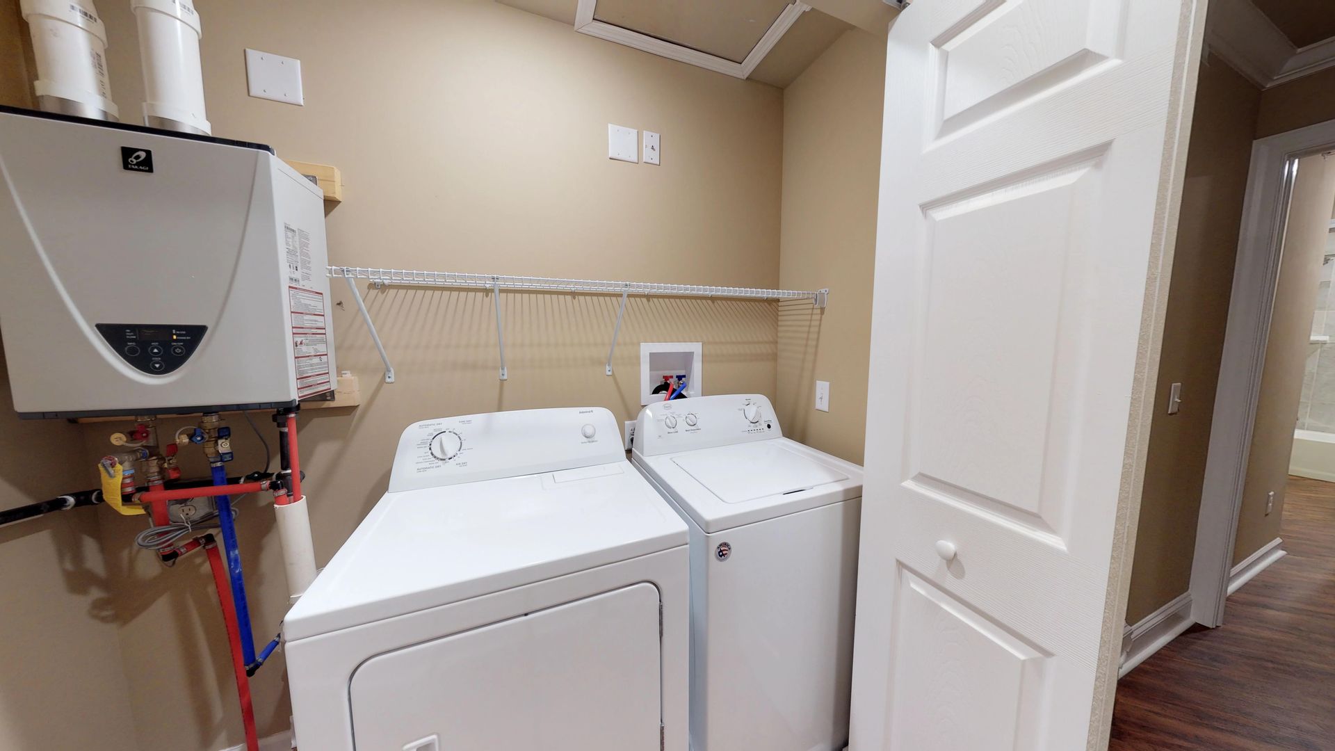 A laundry room with a washer and dryer and a water heater.