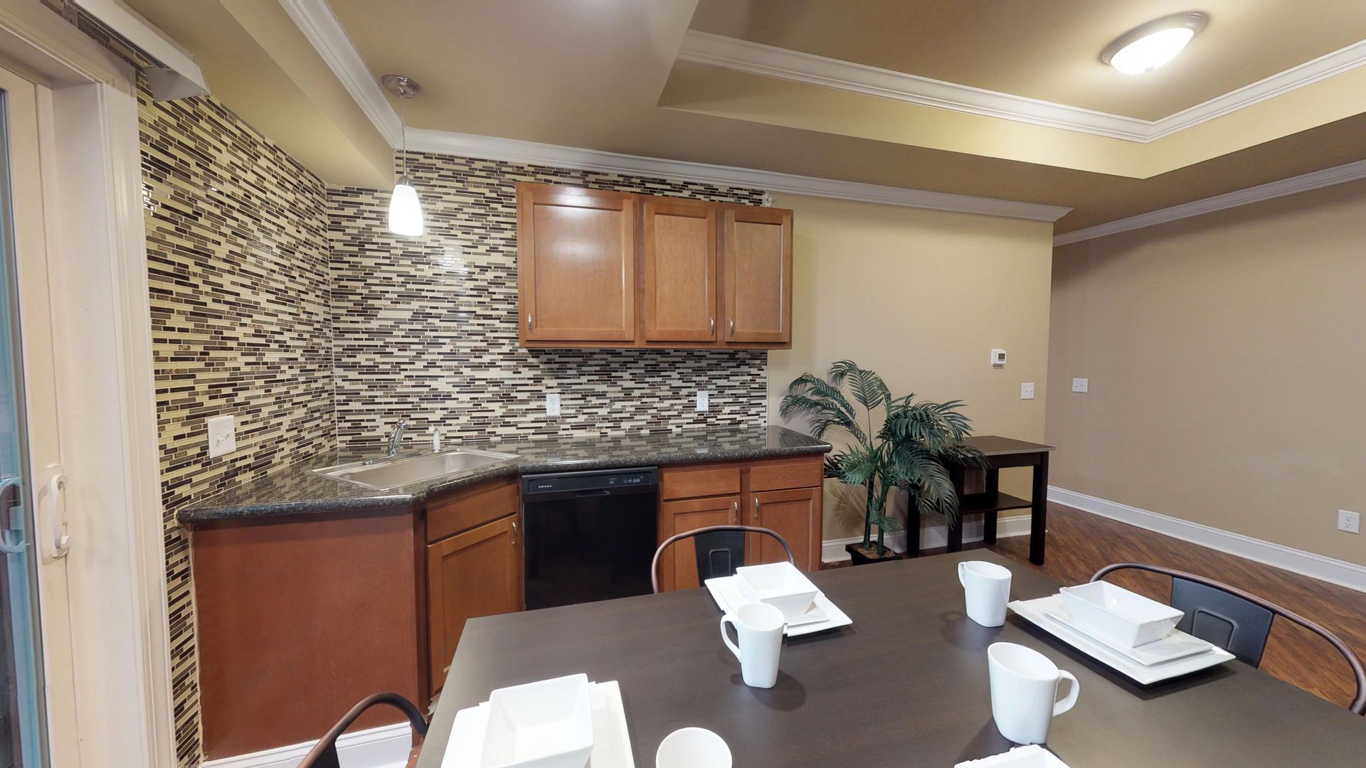 A kitchen with a table and chairs and a dishwasher.