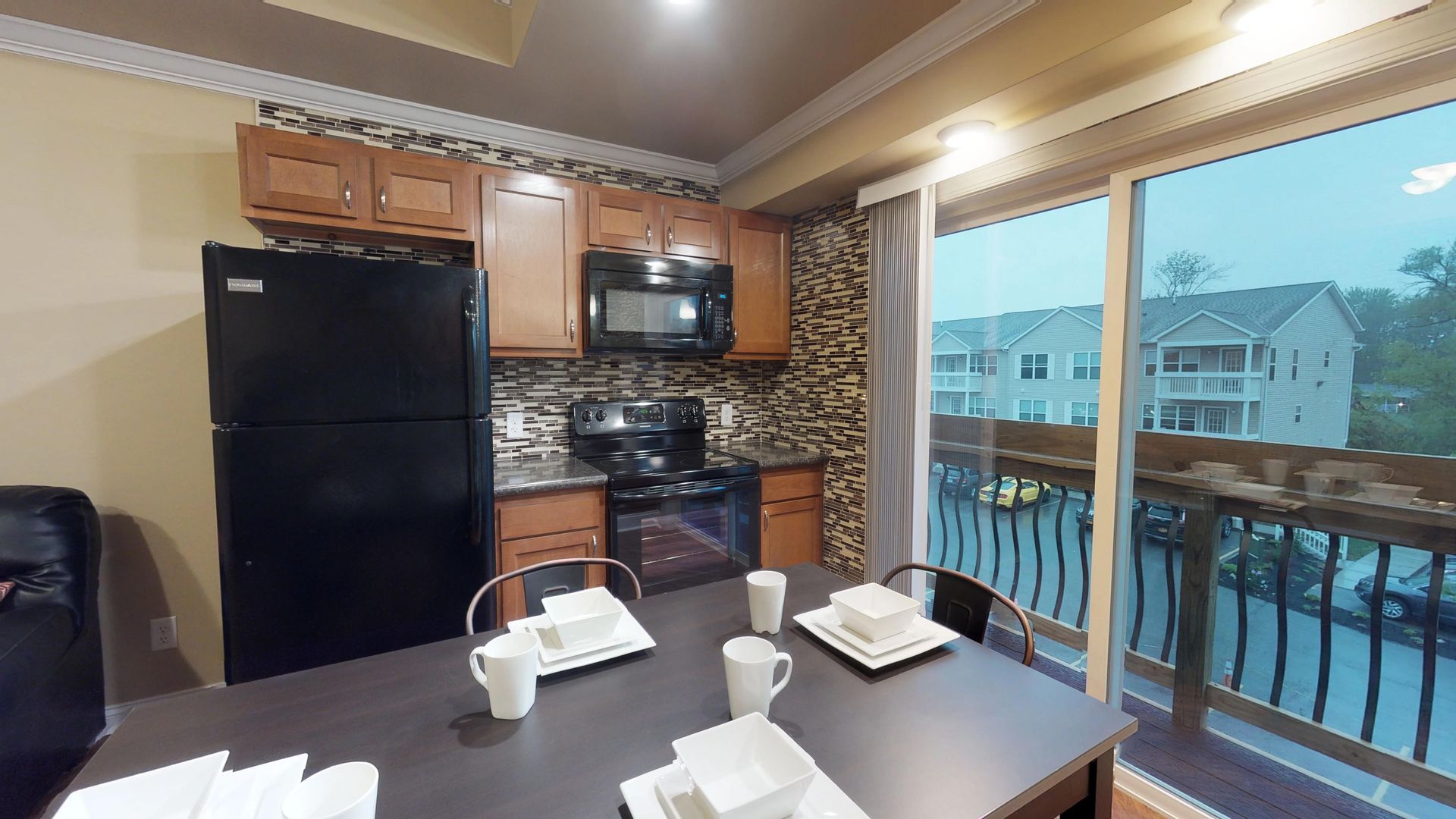 A kitchen with a table and chairs and a sliding glass door.