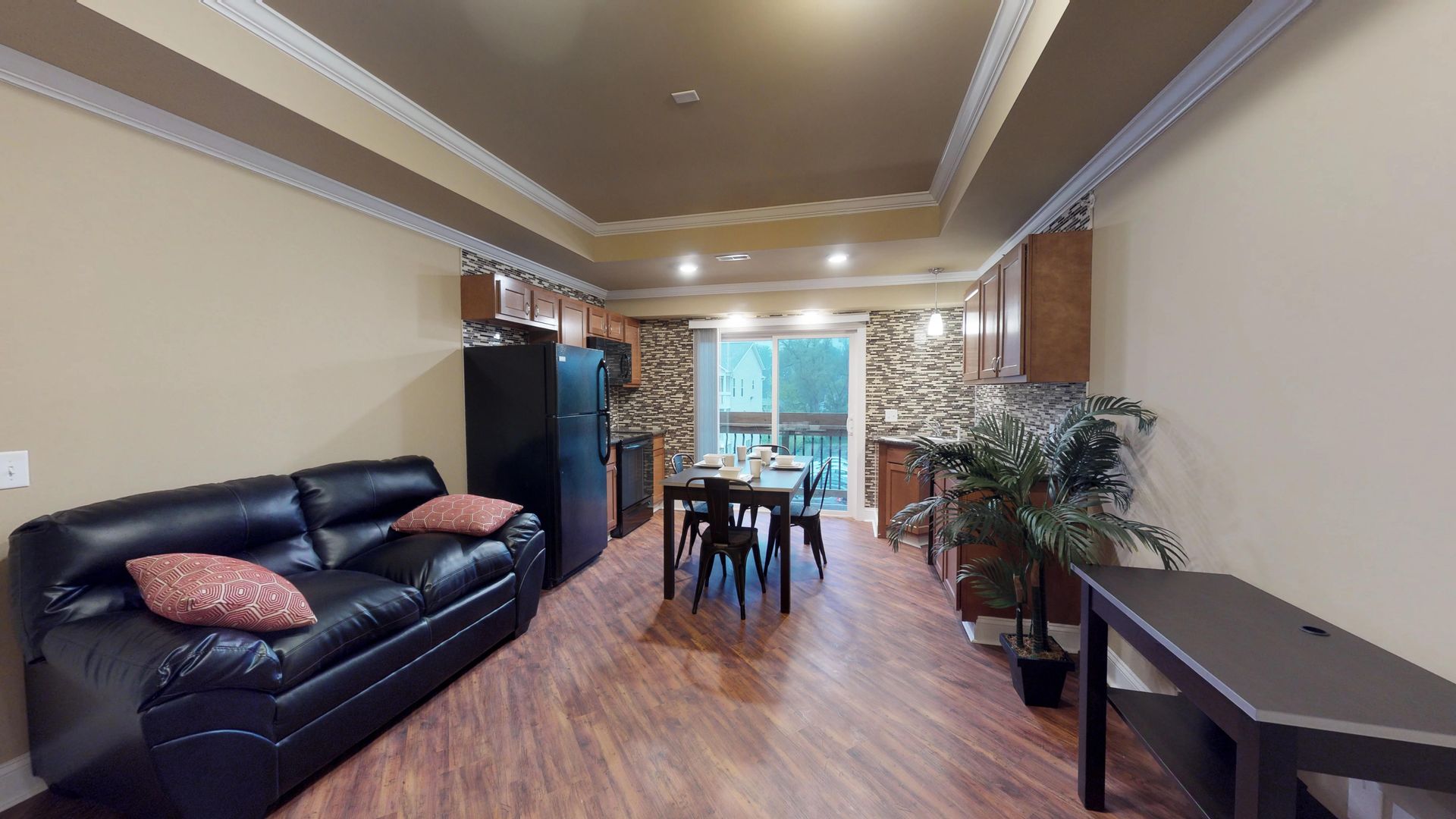 A living room with a couch , table and refrigerator