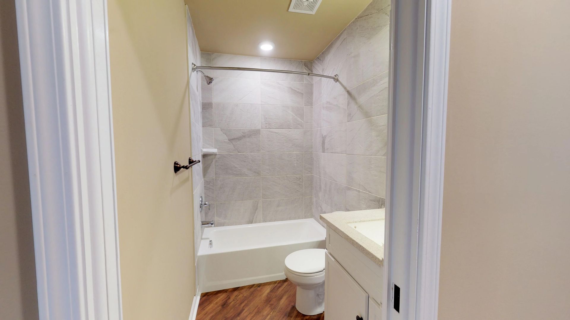 A bathroom with a toilet , sink , bathtub and shower.