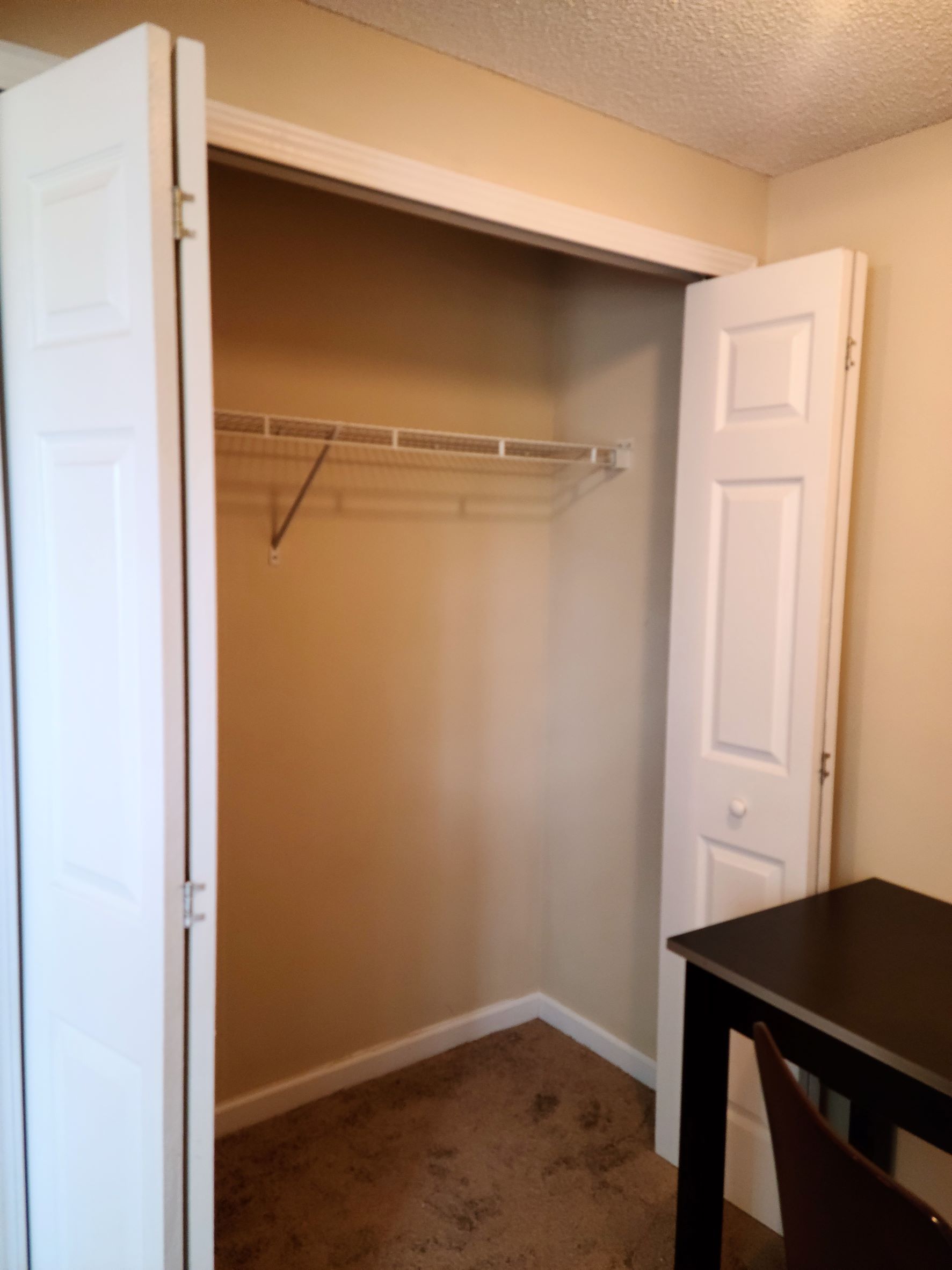 A closet with a desk and chair in it