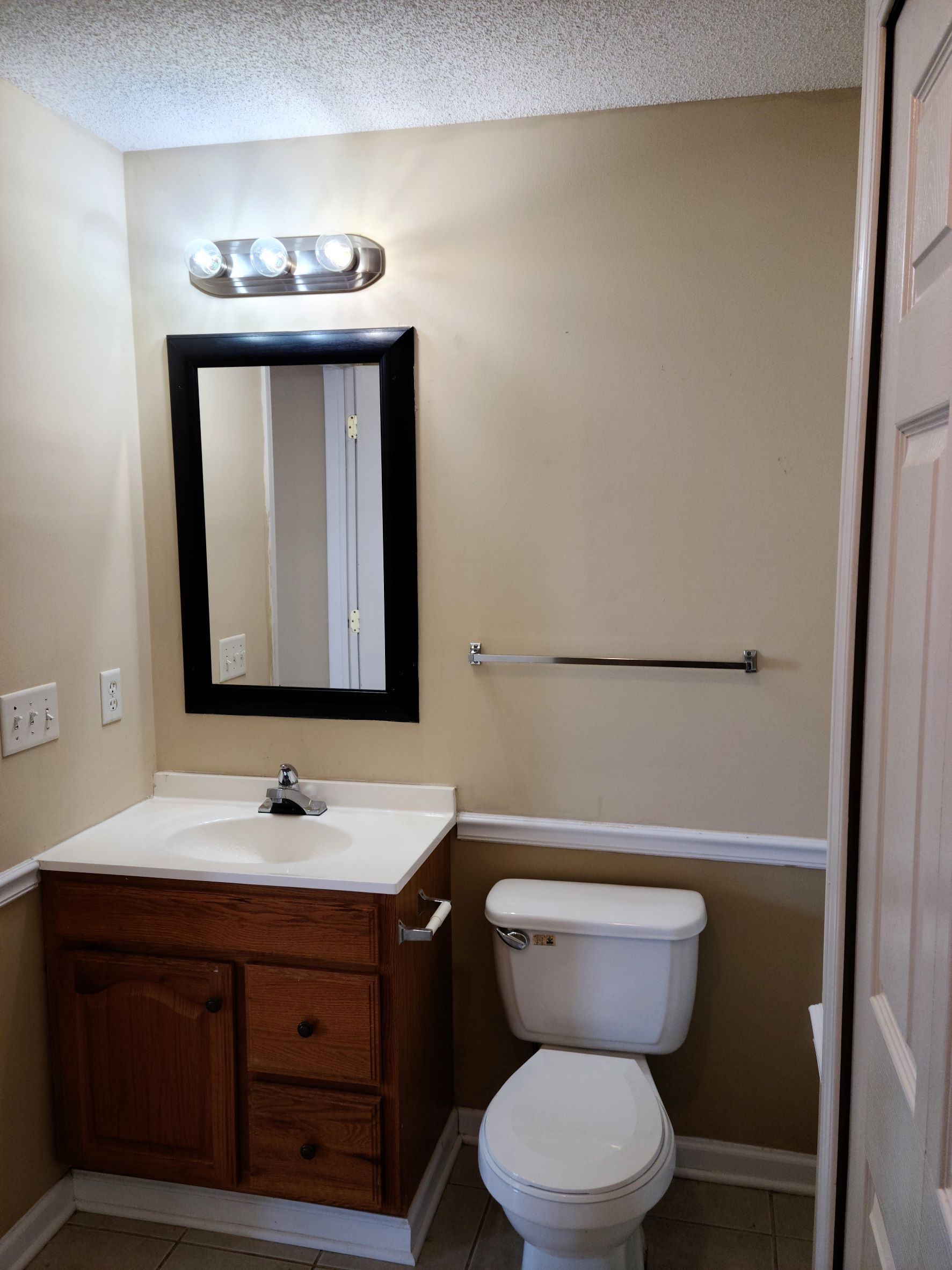 A bathroom with a toilet , sink and mirror