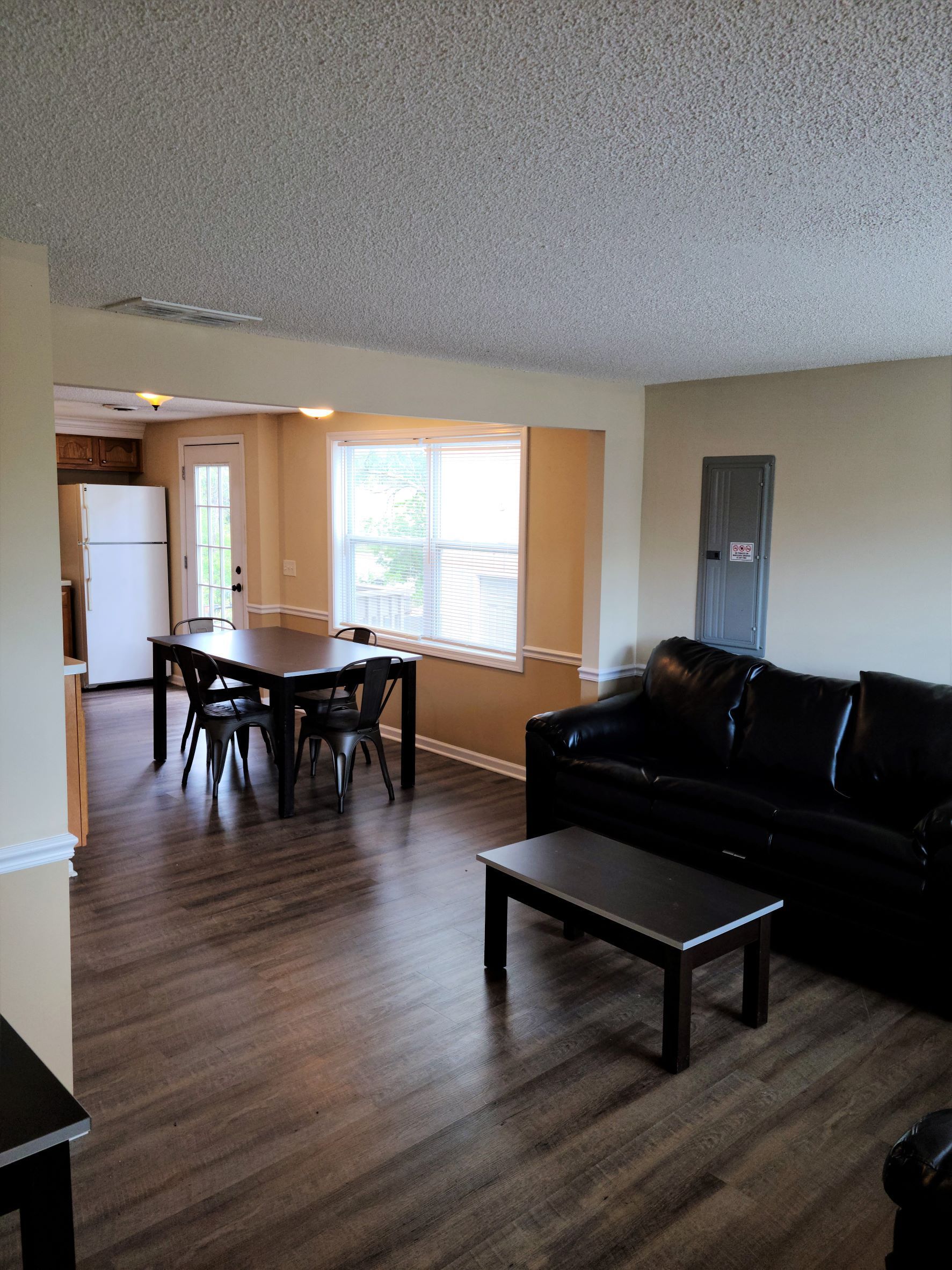A living room with a couch , table and chairs