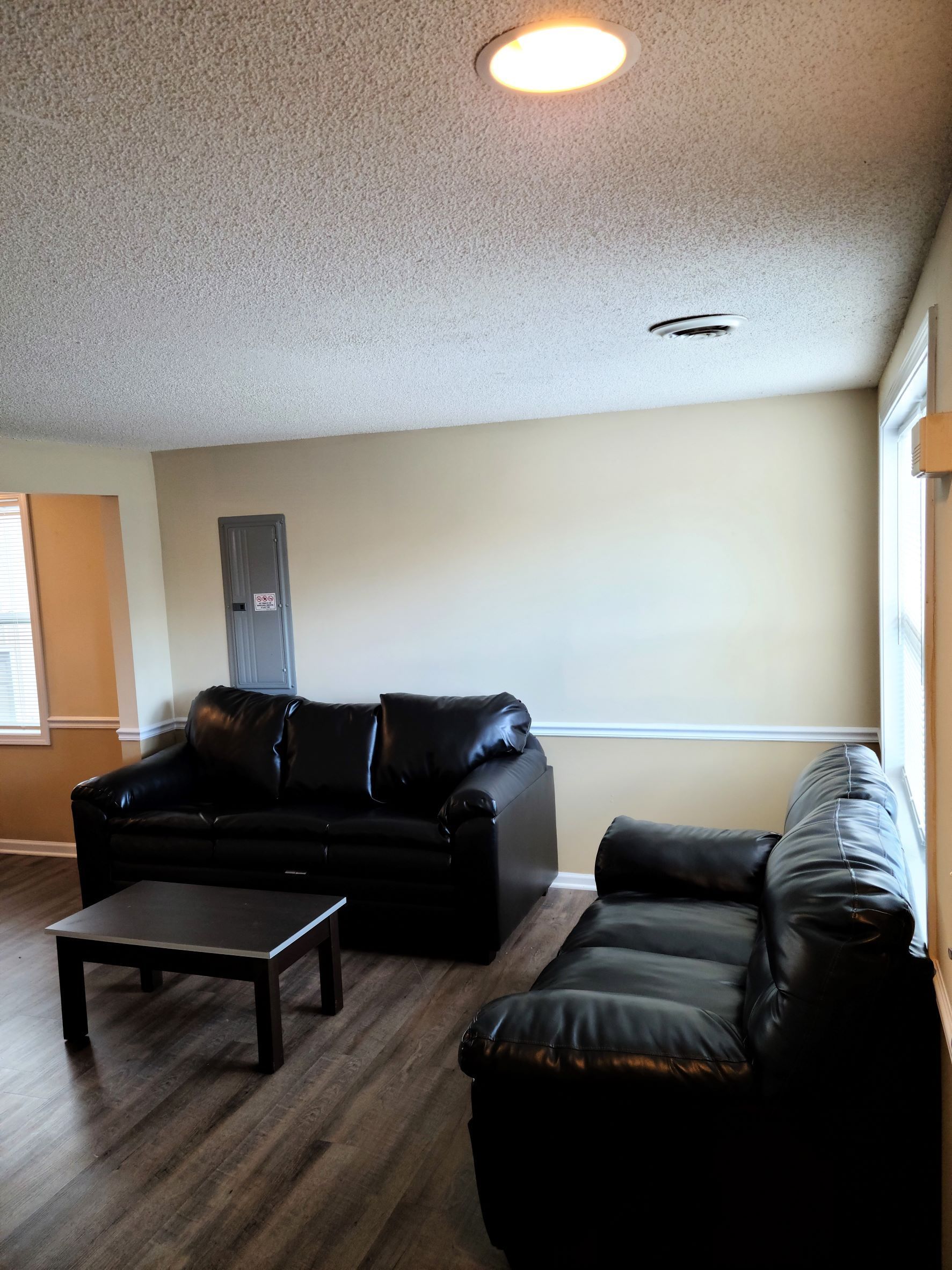 A living room with two couches , a coffee table , and a window.
