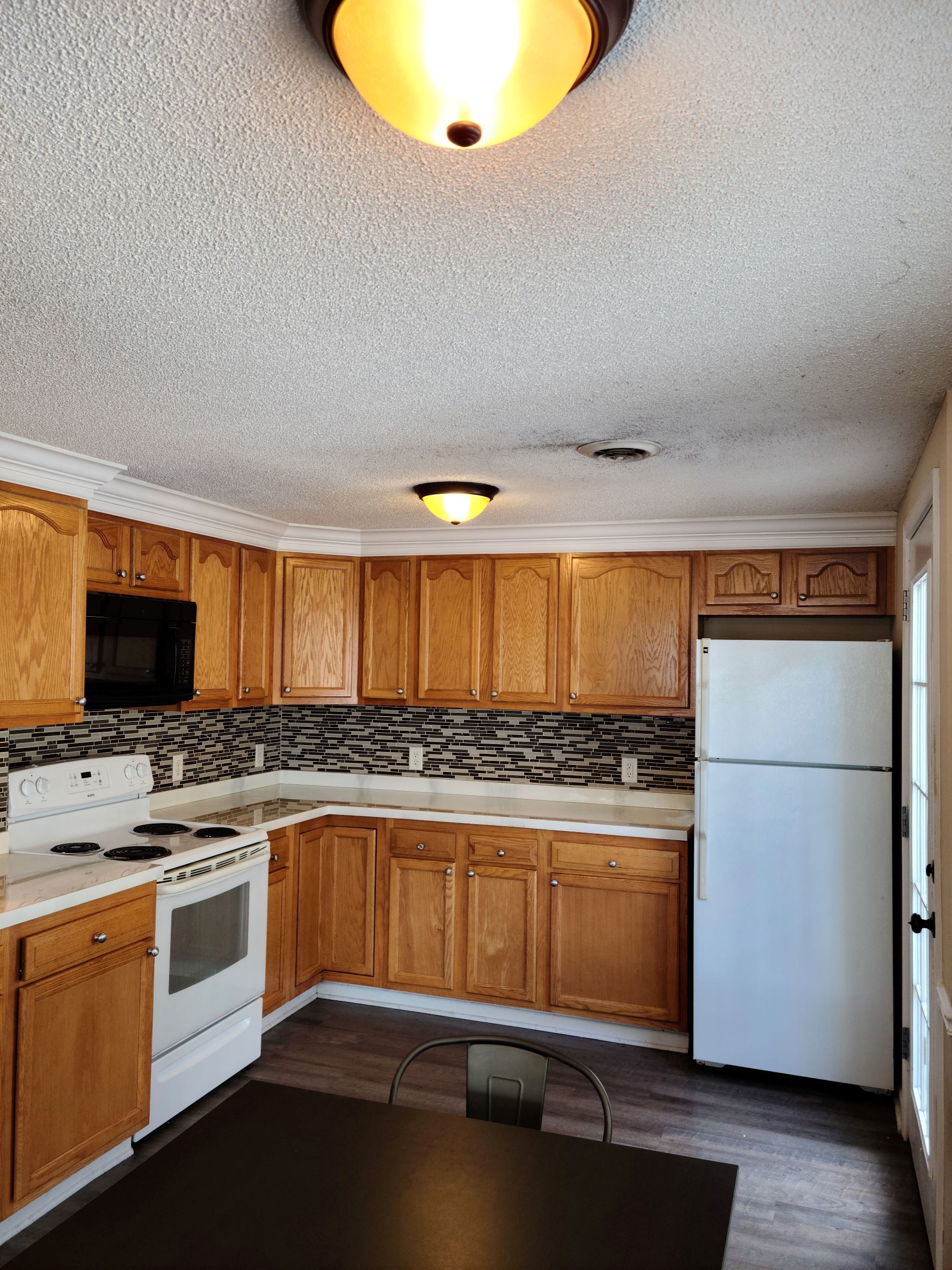 A kitchen with wooden cabinets and a white refrigerator.