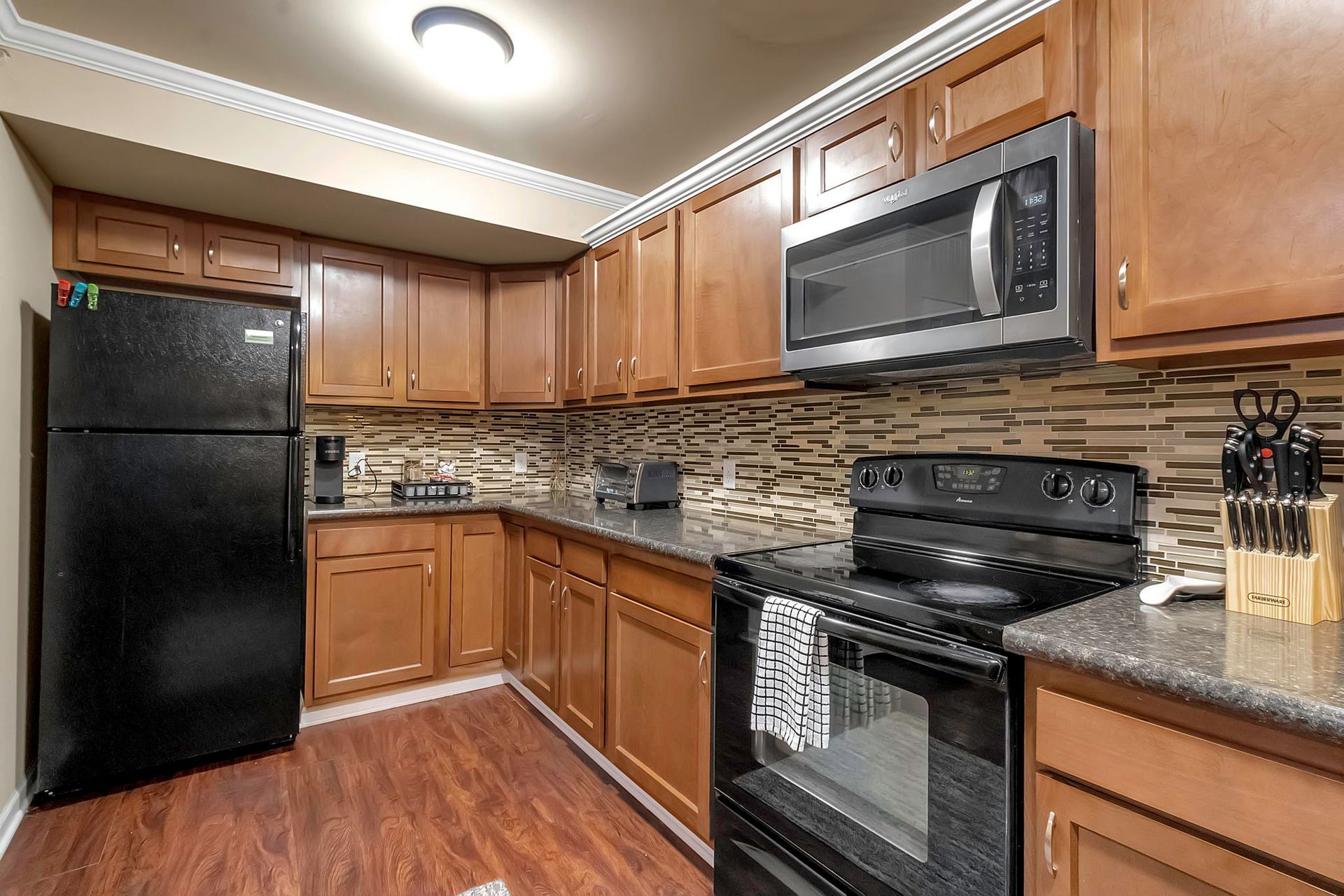 A kitchen with stainless steel appliances and wooden cabinets