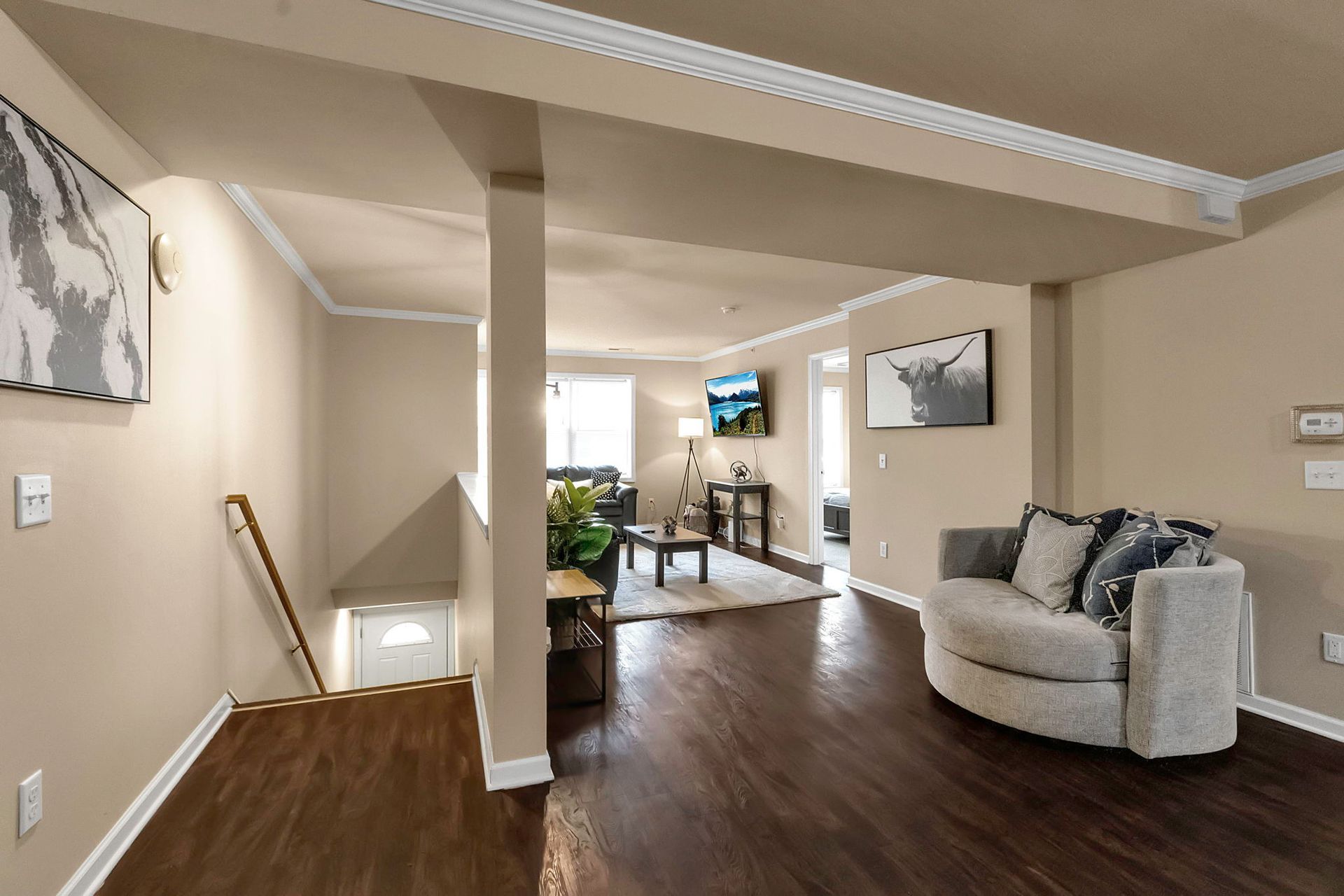 A living room with a couch and stairs leading up to the second floor.