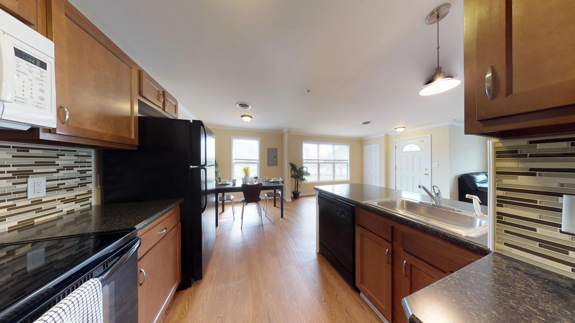 A kitchen with wooden cabinets and a black refrigerator