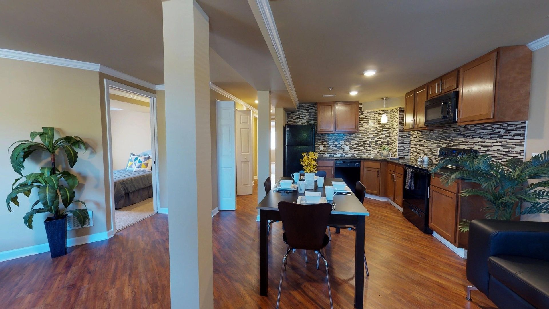 A living room with a dining table and chairs and a kitchen.