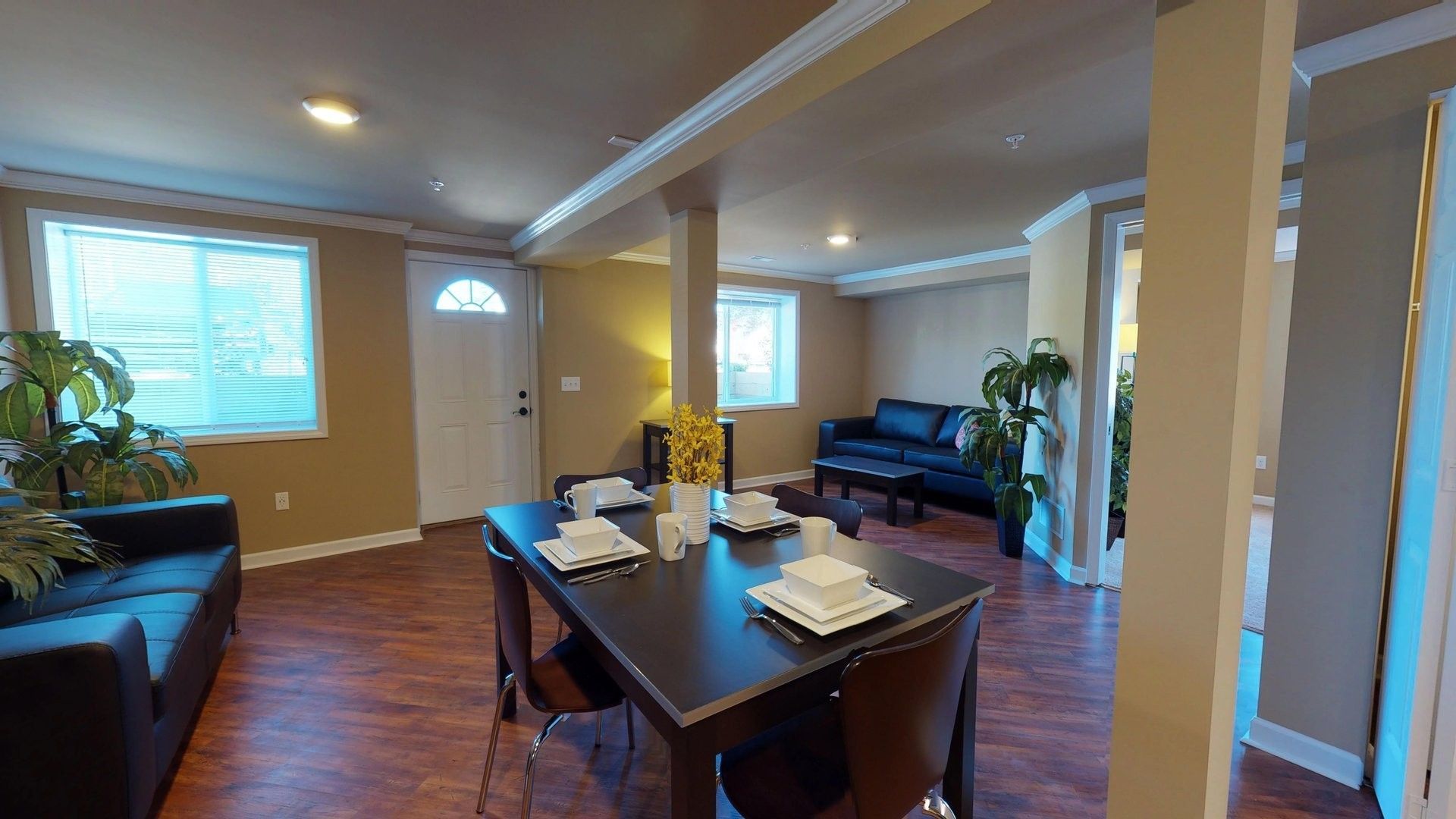 A living room with a dining table and chairs and a couch.