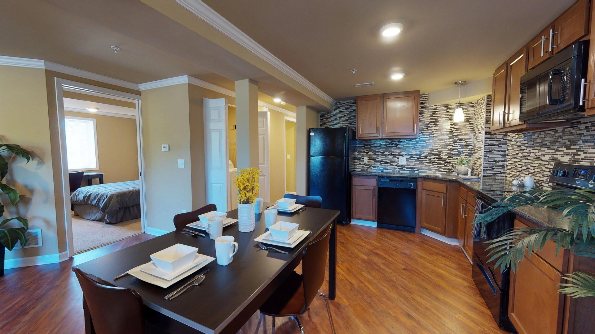 A kitchen with a dining table and chairs and a refrigerator.