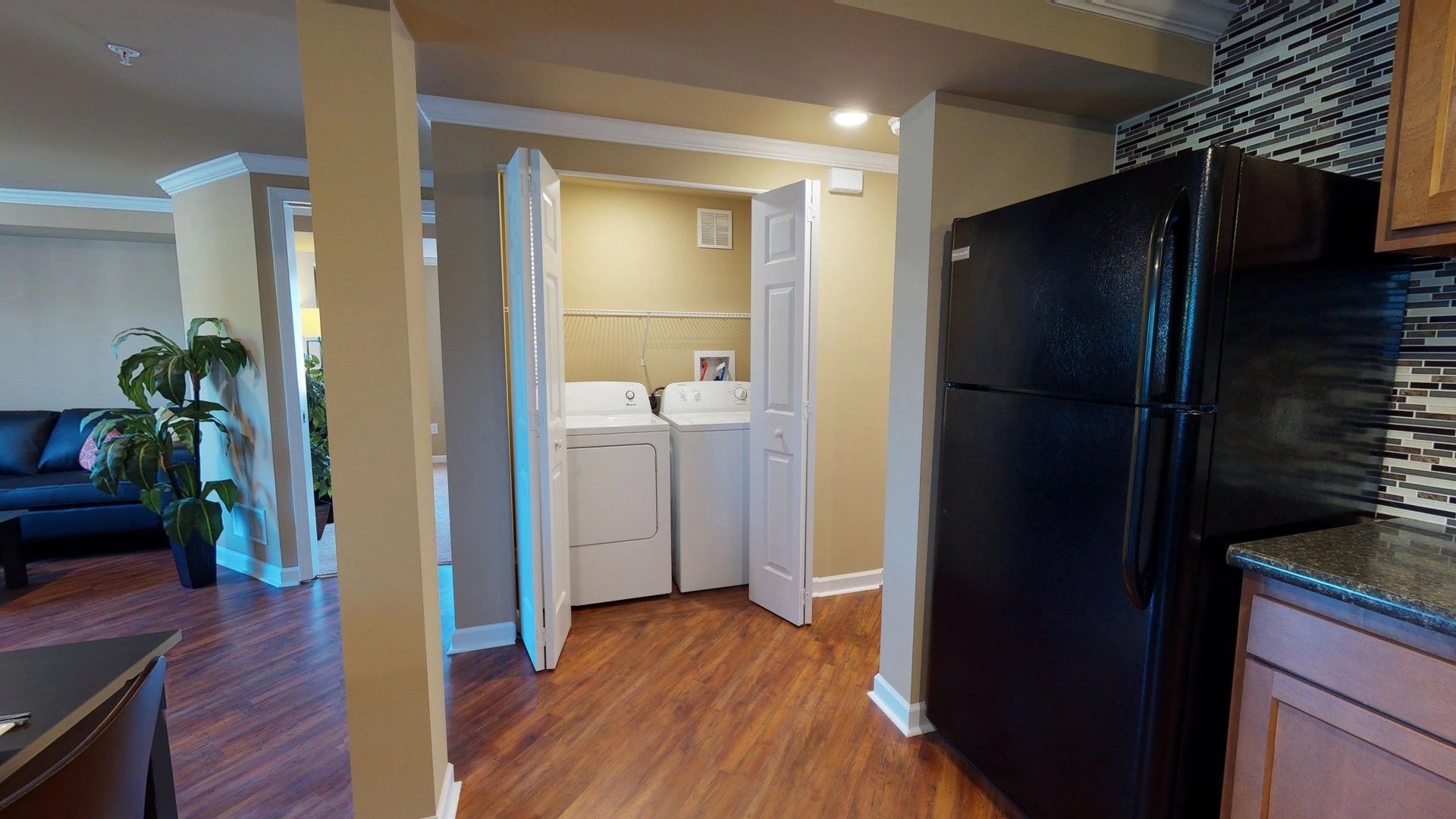 A laundry room with a washer and dryer and a refrigerator.