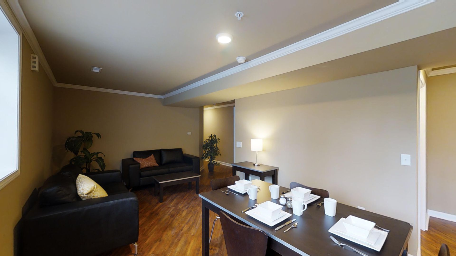 A living room with a dining table and chairs and a couch.