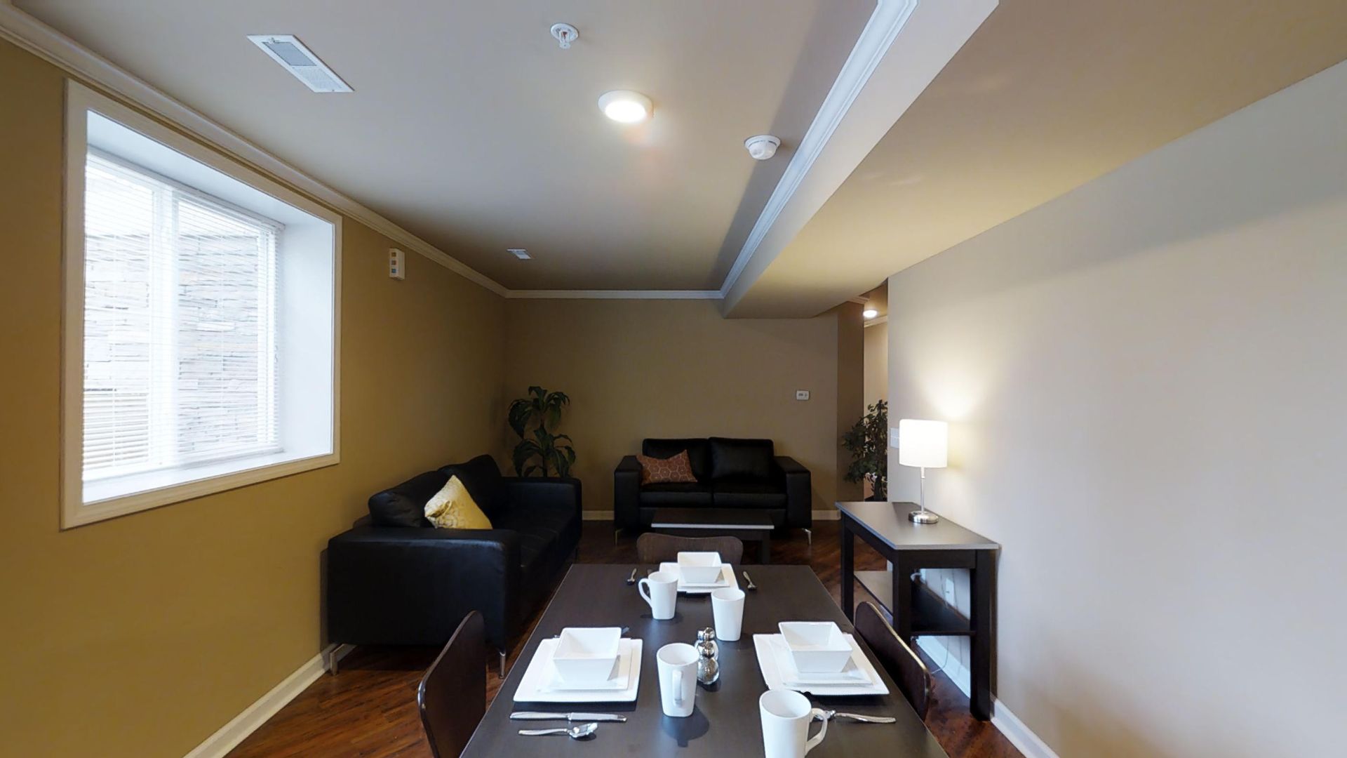 A living room with a table and chairs and a couch.