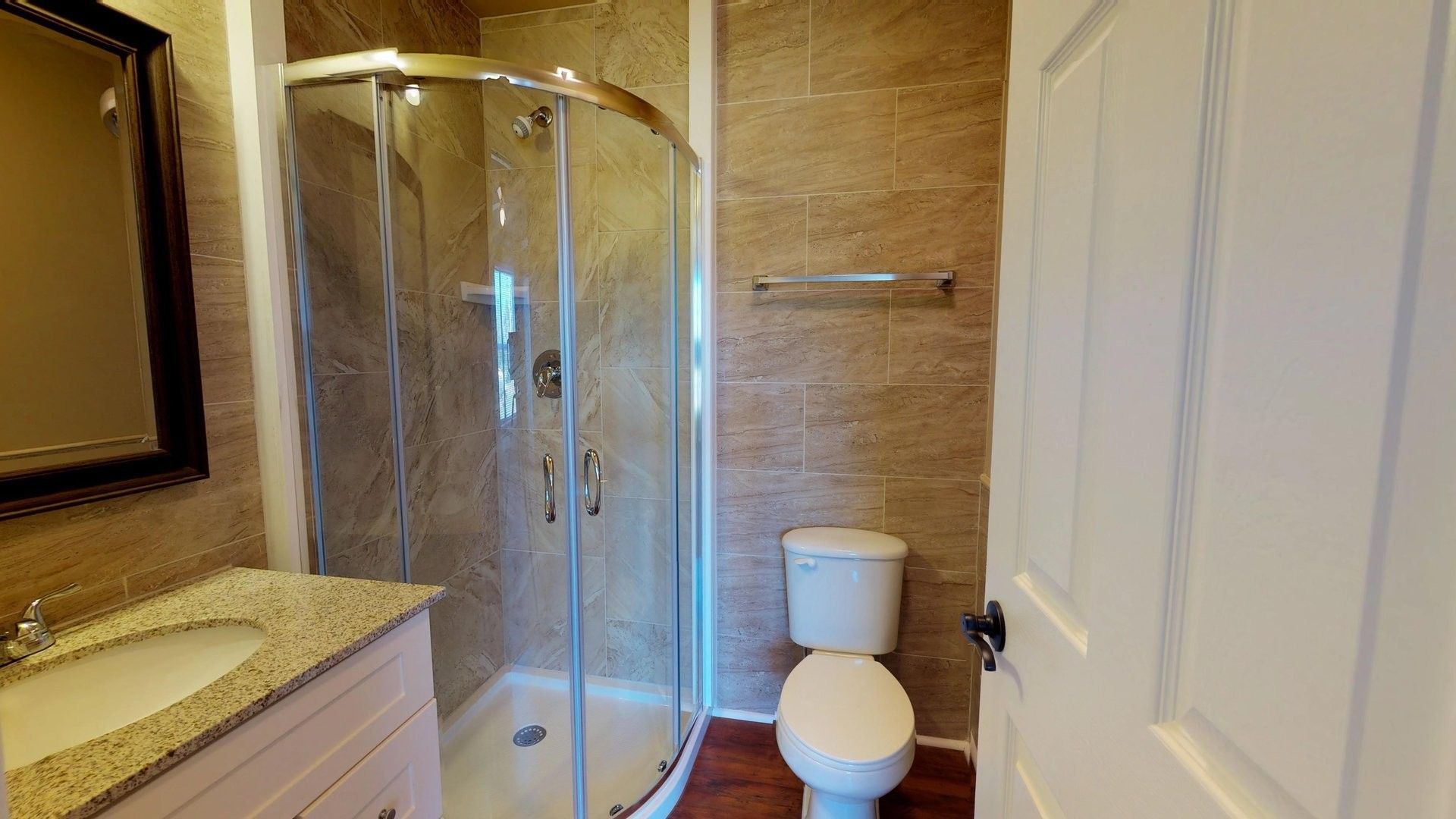 A bathroom with a toilet , sink and shower stall.
