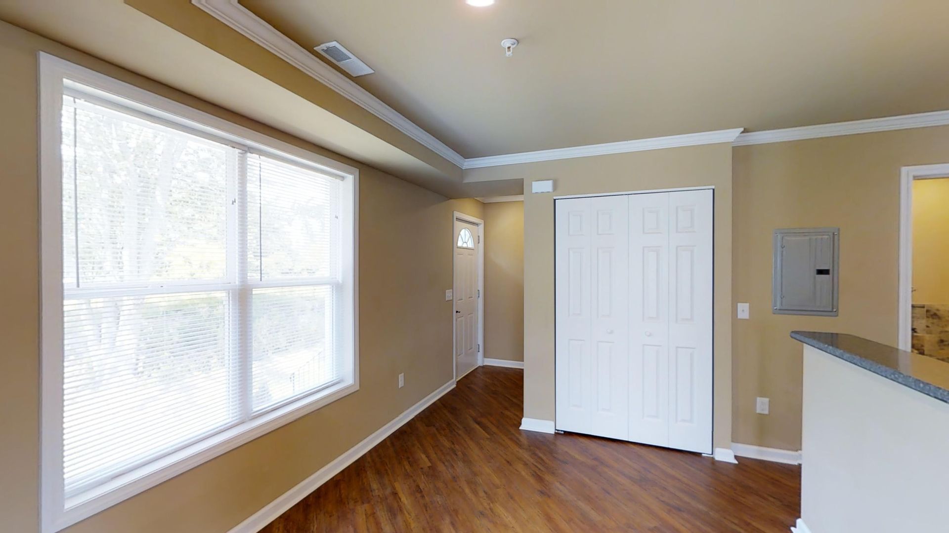 A living room with hardwood floors and a large window.