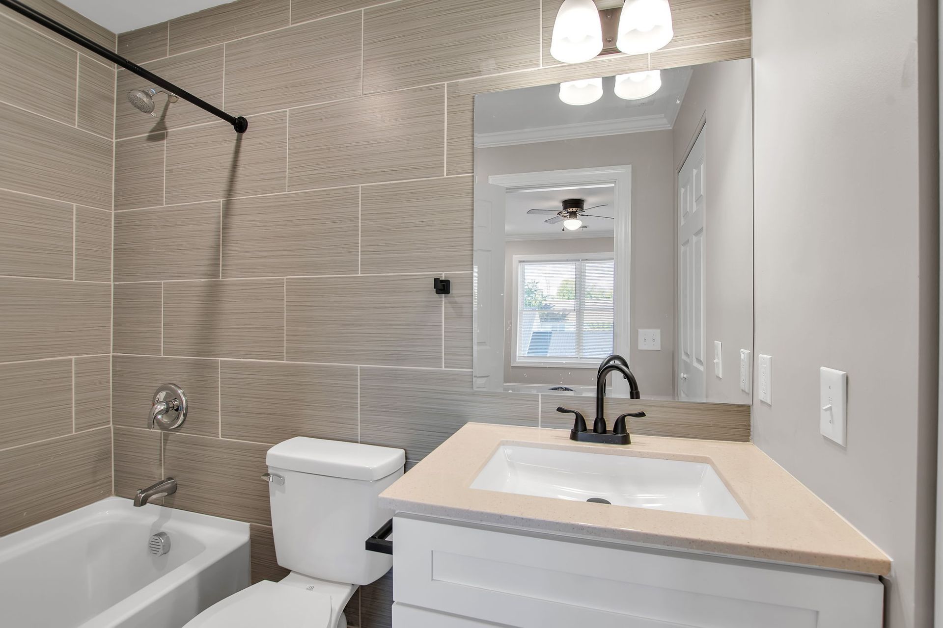 Bathroom with polished tile surfaces and updated plumbing hardware