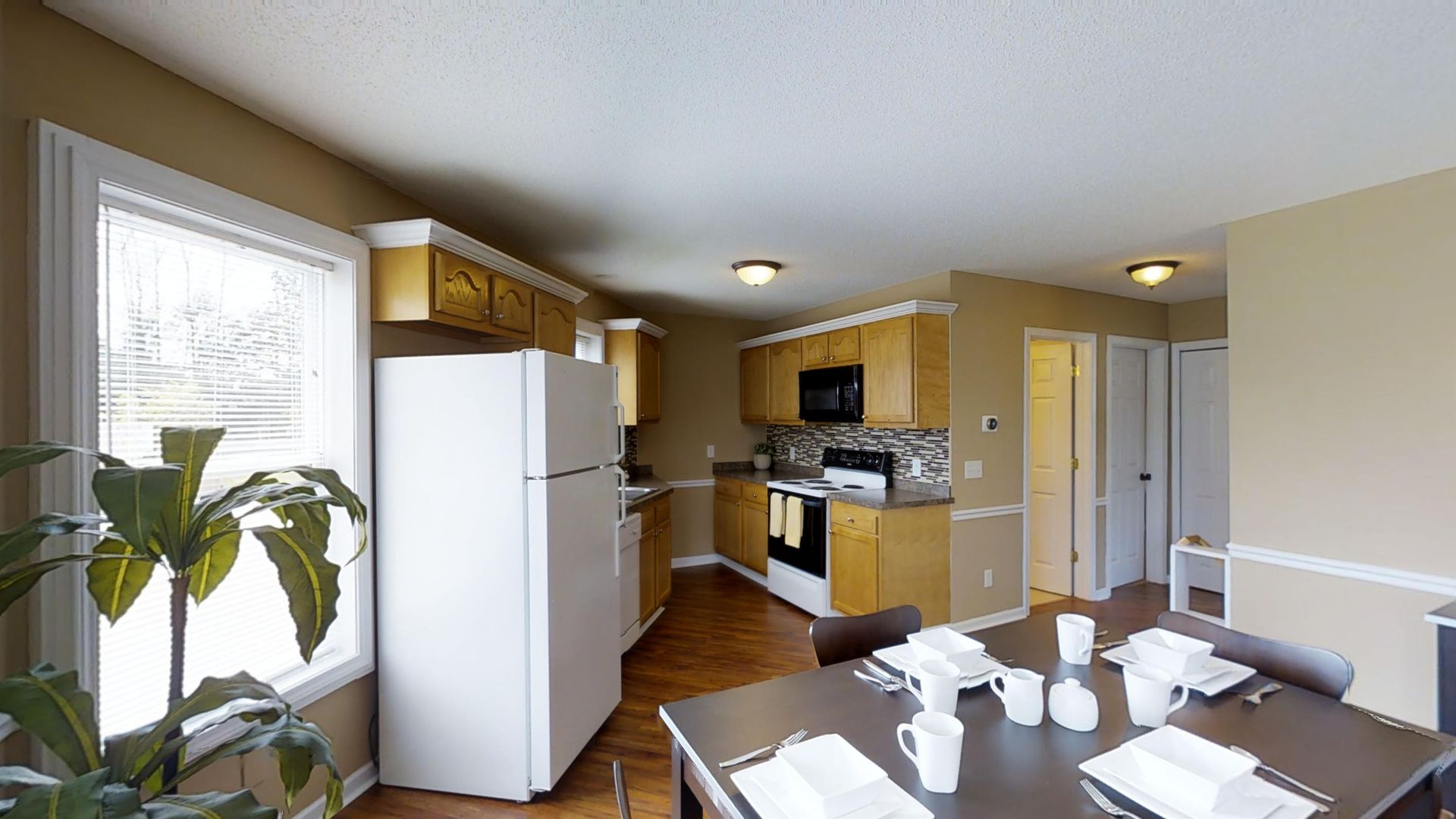 A kitchen with a table and chairs and a refrigerator.