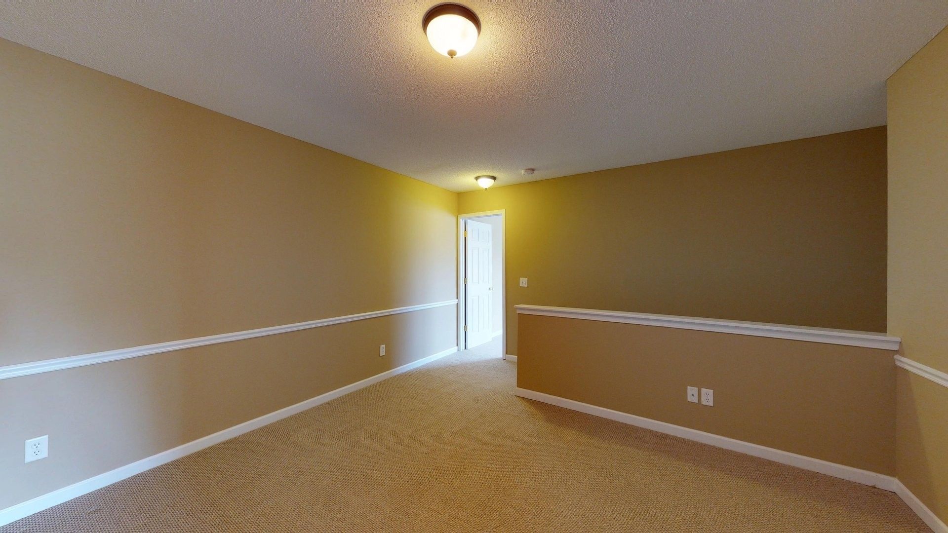 An empty room with a ceiling fan and a door.