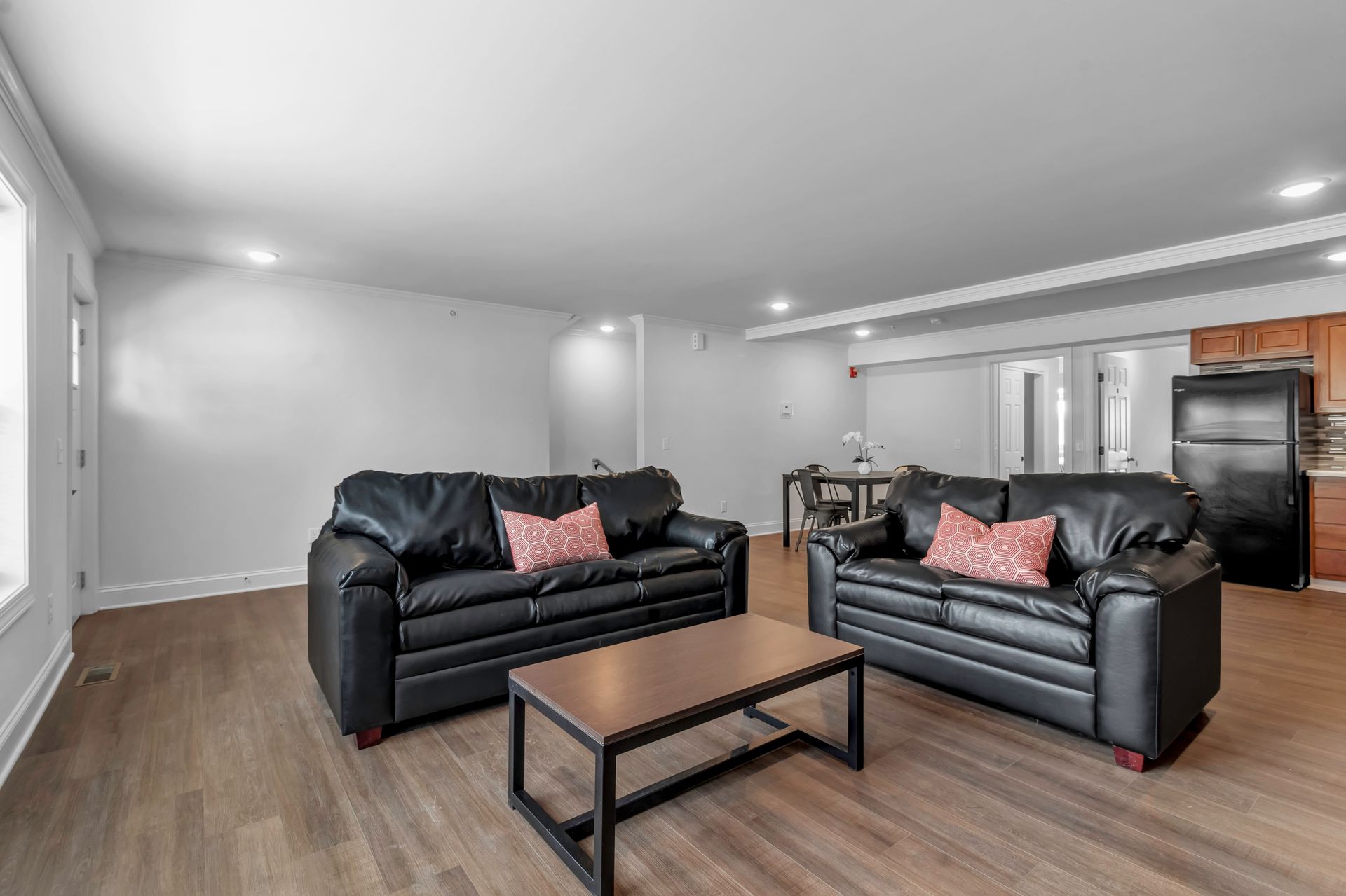 A living room with two black couches and a coffee table.