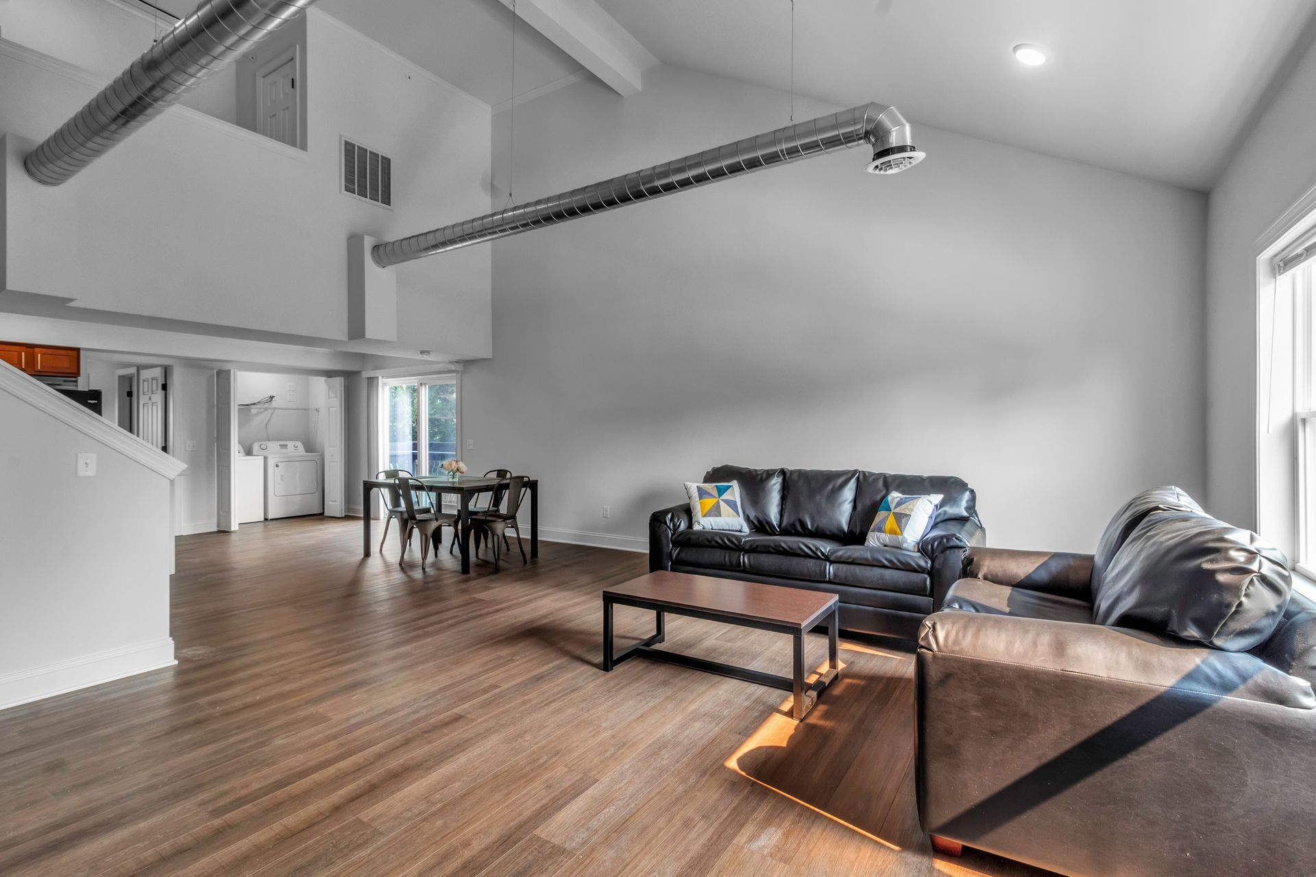 A living room with a couch , table and chairs.
