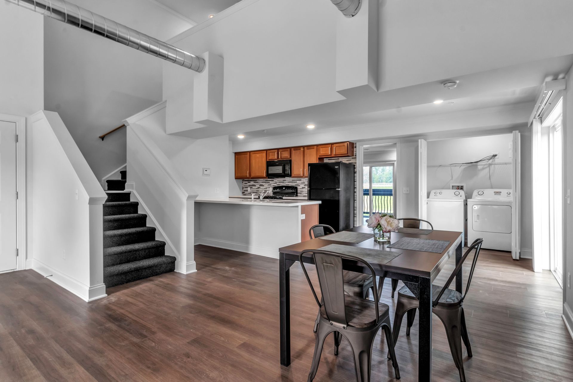 There is a dining table and chairs in the middle of the room.