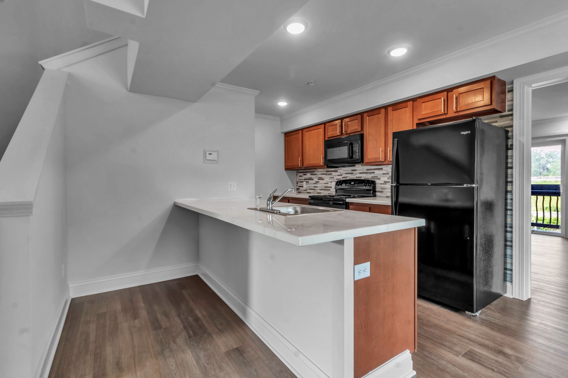 A kitchen with a refrigerator , stove , microwave and sink.