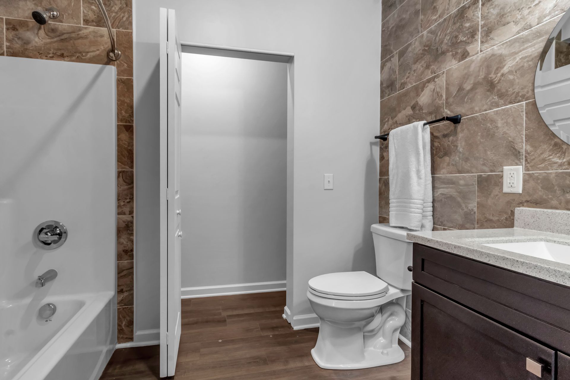 A bathroom with a toilet , sink , bathtub and shower.