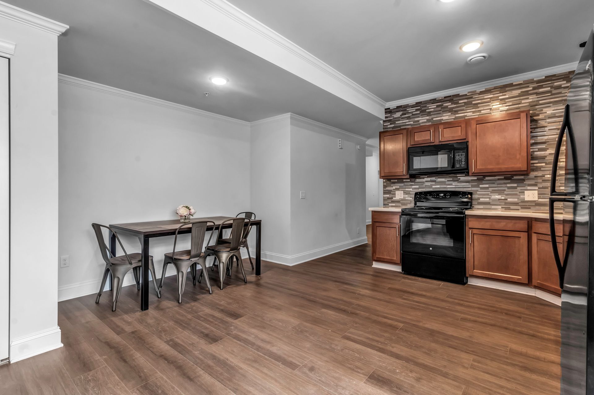 A kitchen with a table and chairs and a refrigerator.