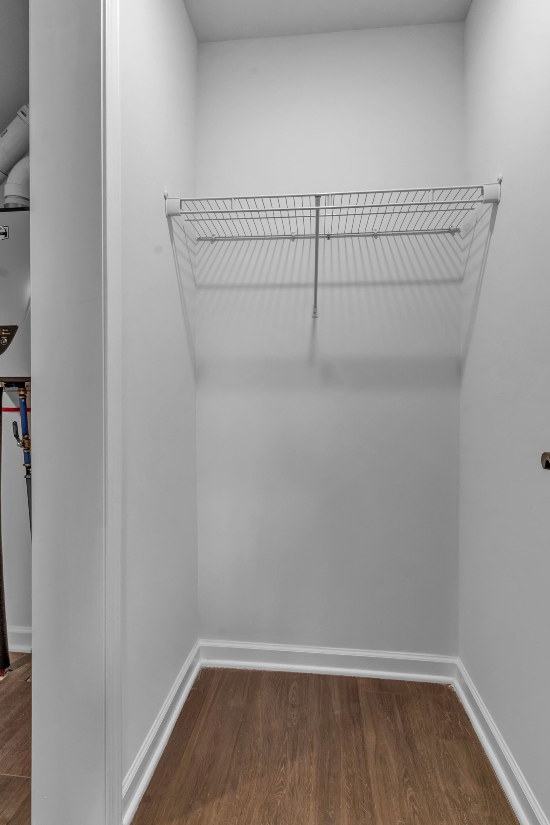 An empty walk in closet with a wire rack on the wall.