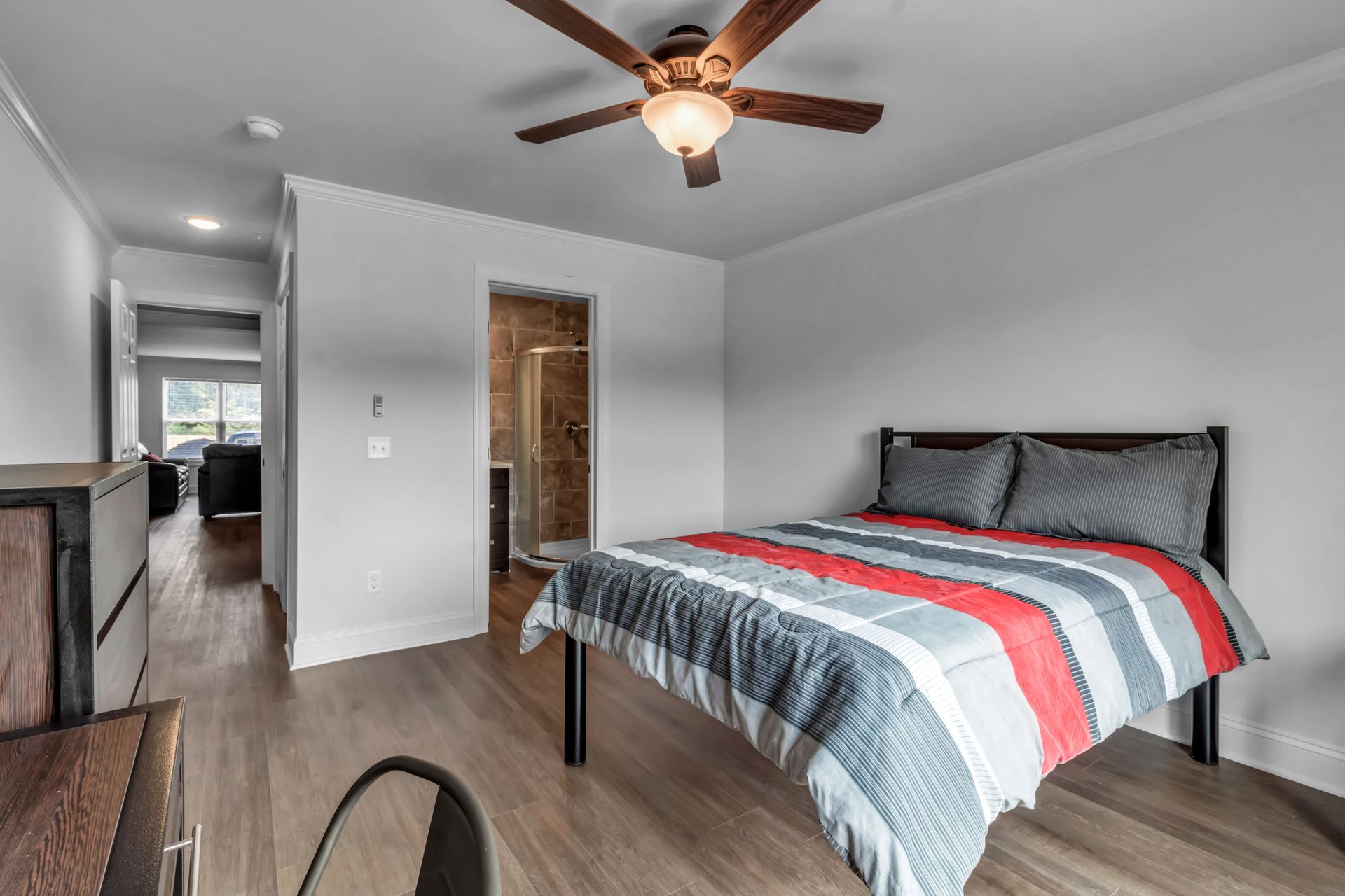 A bedroom with a bed and a ceiling fan.