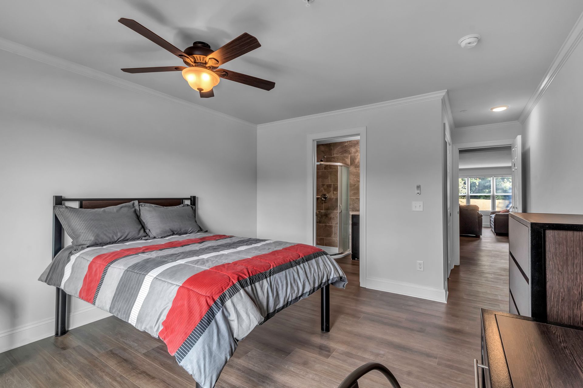 A bedroom with a bed and a ceiling fan.