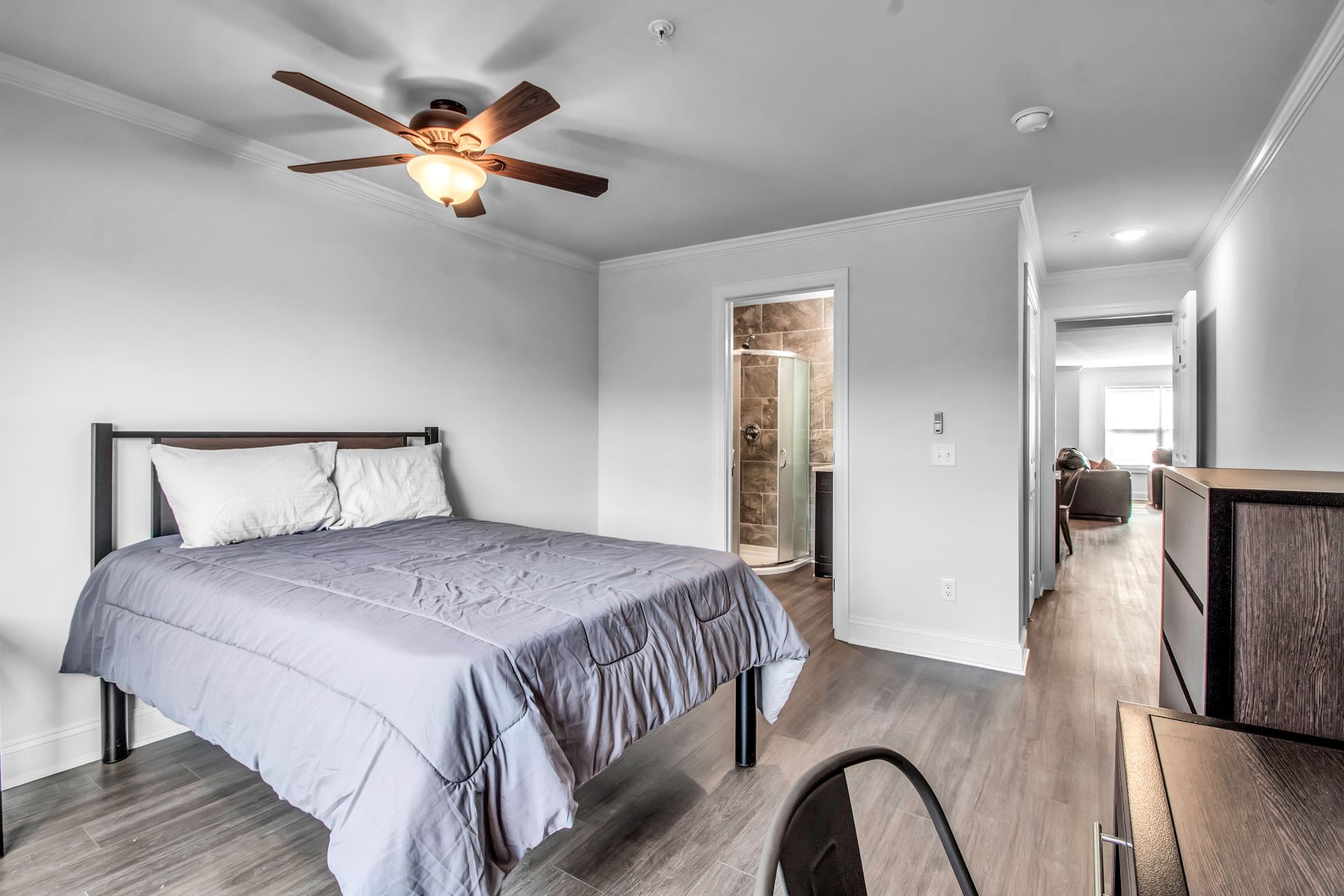 A bedroom with a bed and a ceiling fan.