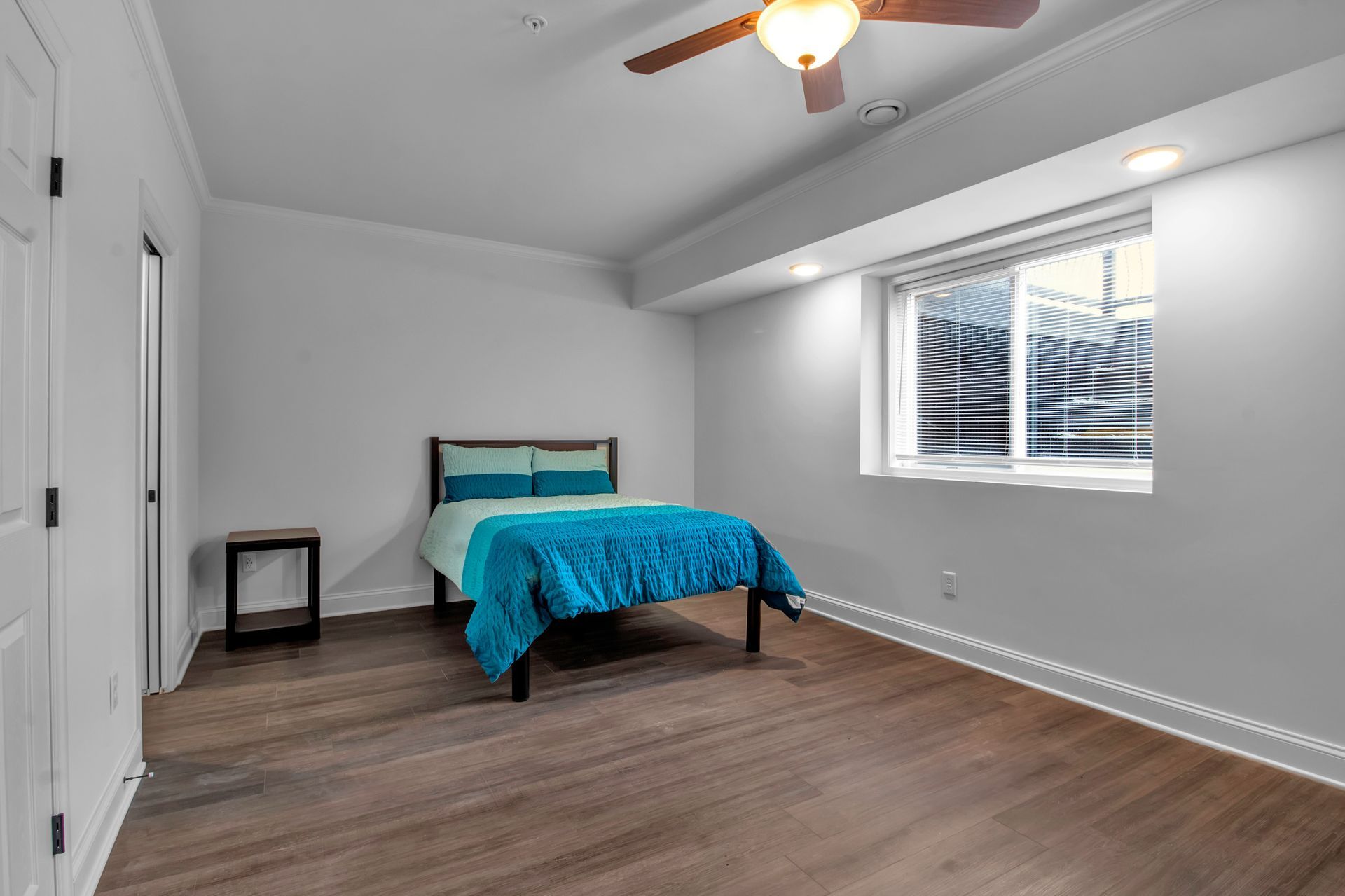 A bedroom with a bed and a ceiling fan.