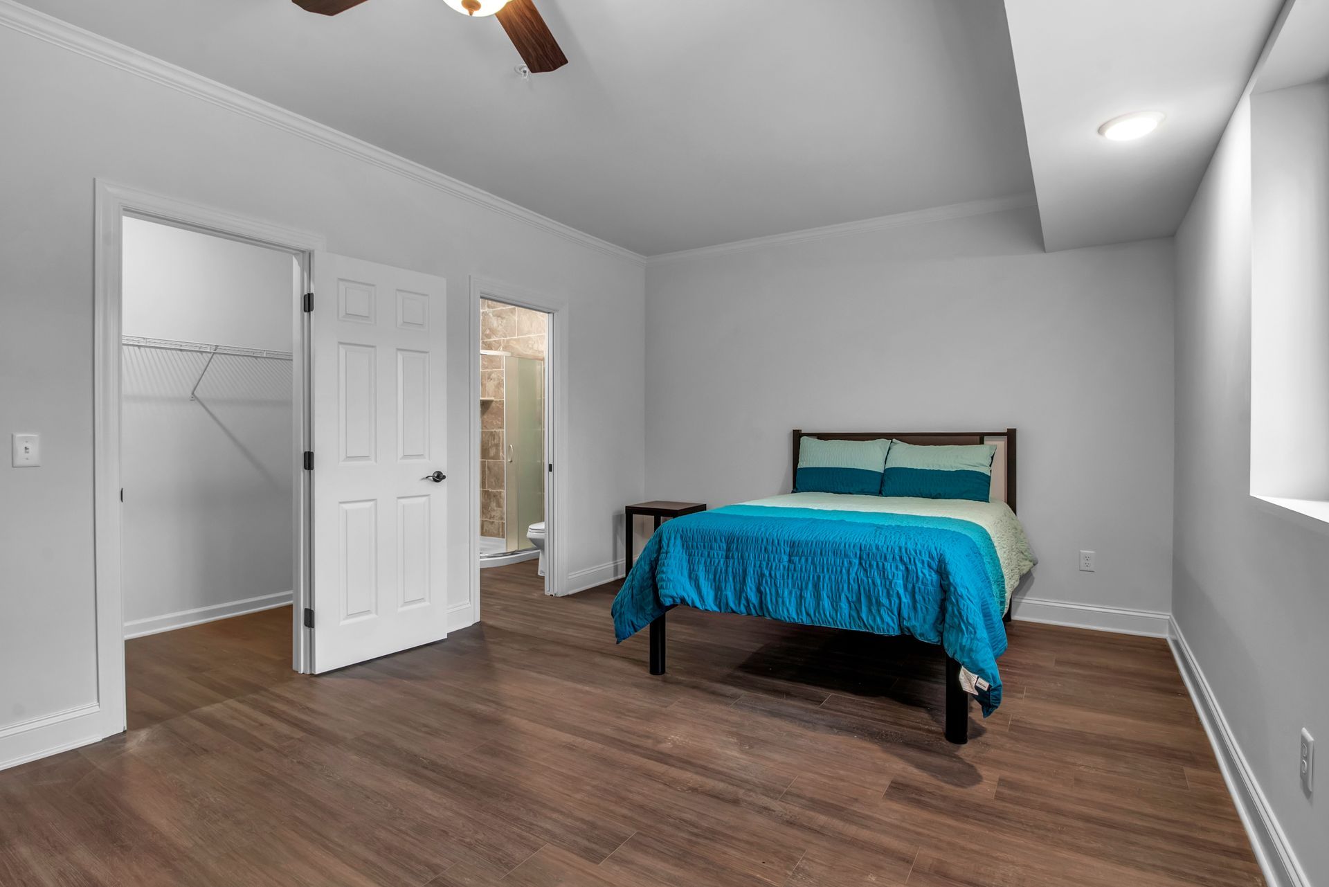 A bedroom with a bed and a ceiling fan.