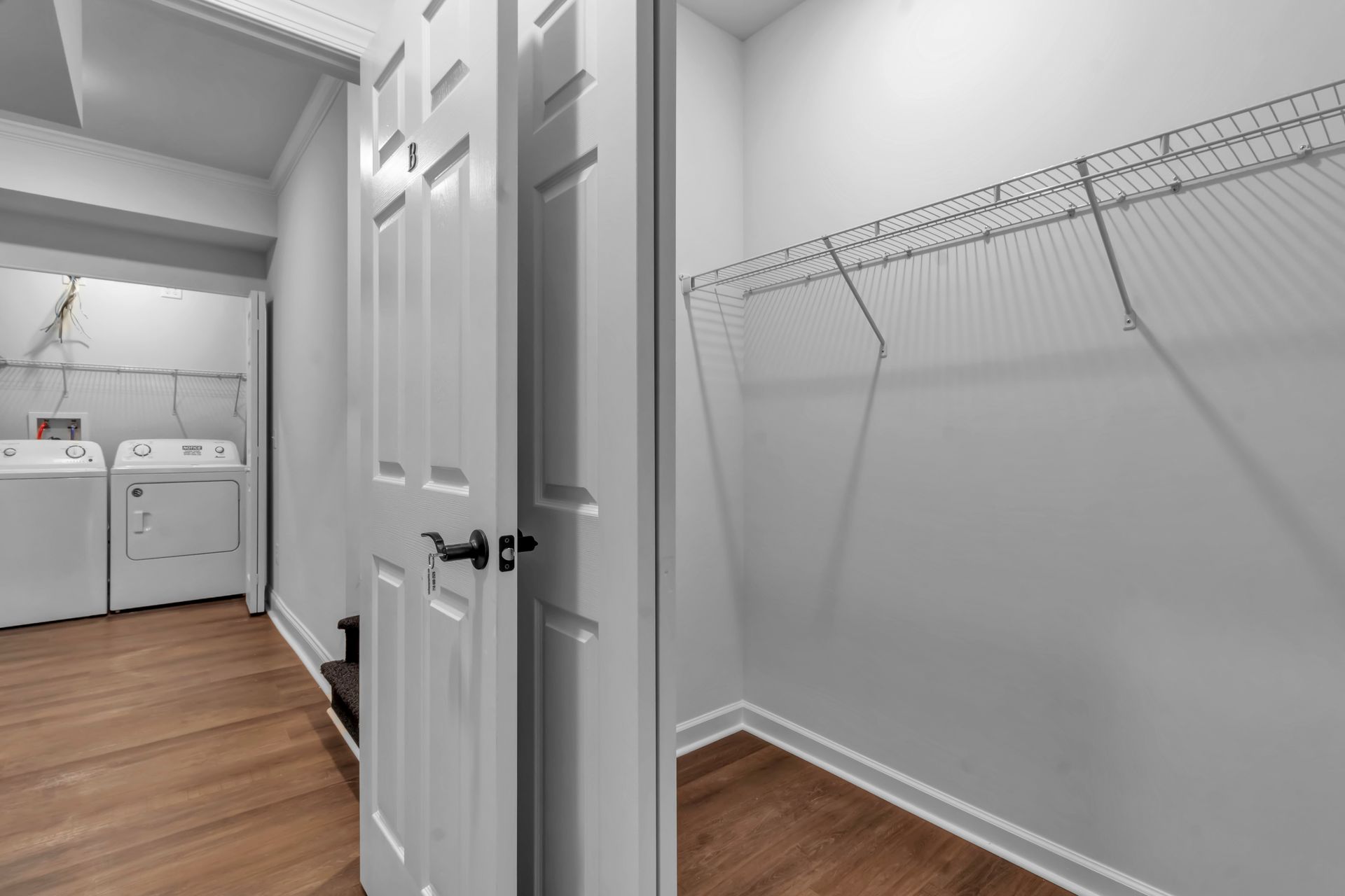 A laundry room with a washer and dryer and a walk in closet.