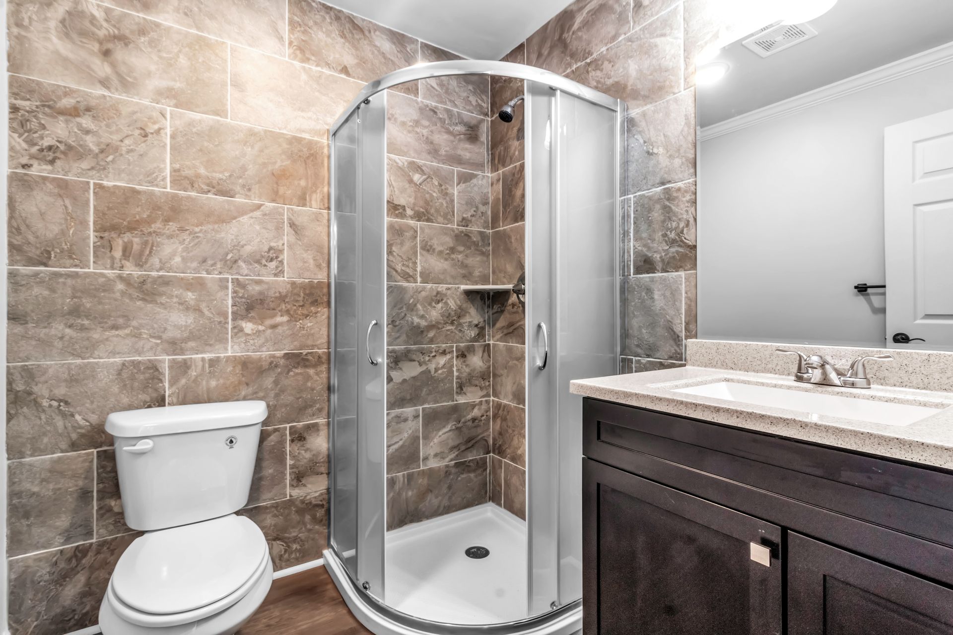 A bathroom with a toilet , sink , and shower stall.